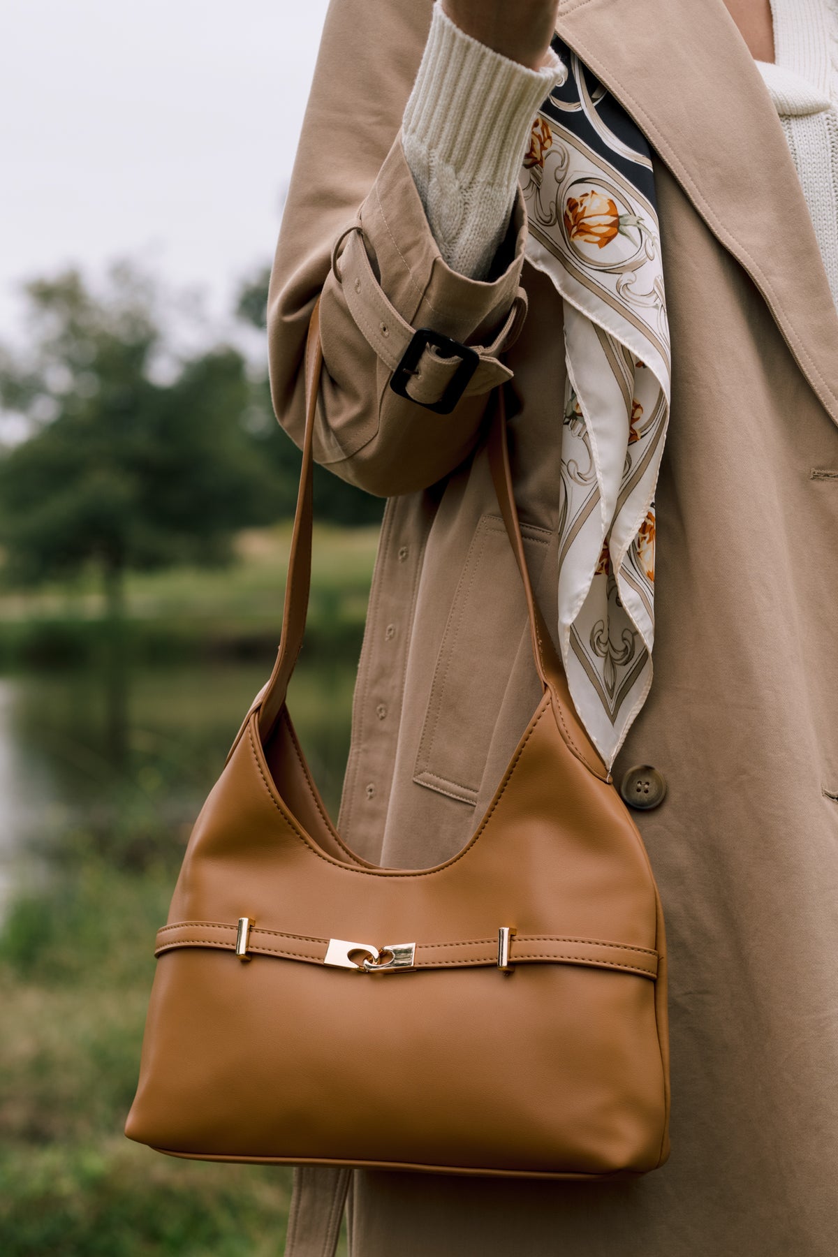Camel faux leather shoulder bag with a softly structured silhouette, magnetic snap closure, and polished gold-tone hardware.