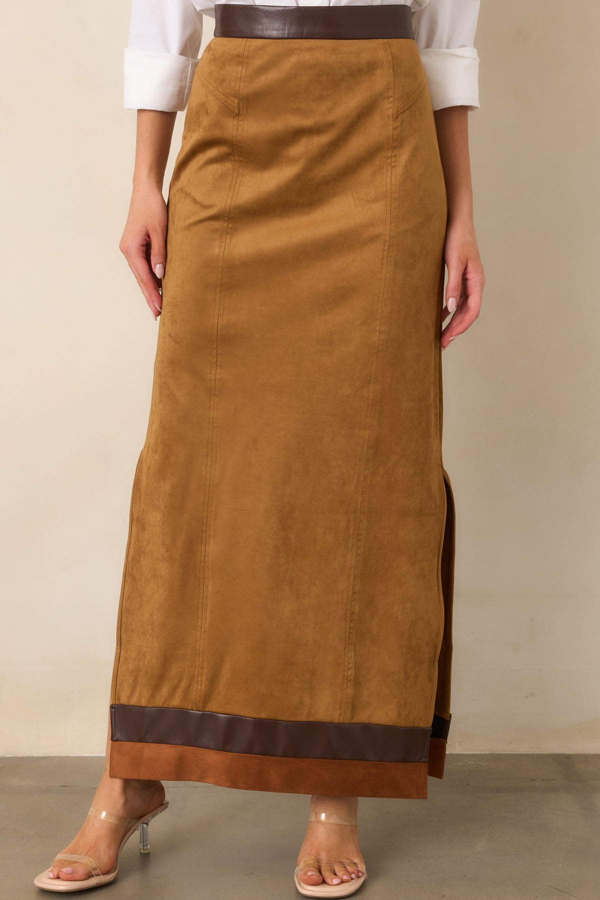 Faux suede camel skirt featuring rich brown contrast trim and defined vertical seams.
