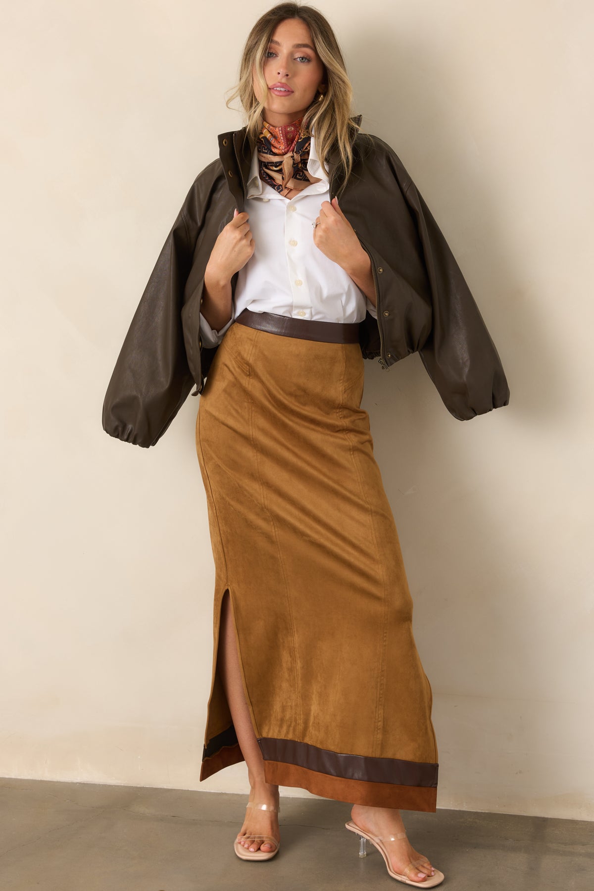 Long camel faux suede skirt with chocolate brown trim near the hem and subtle side slits.
