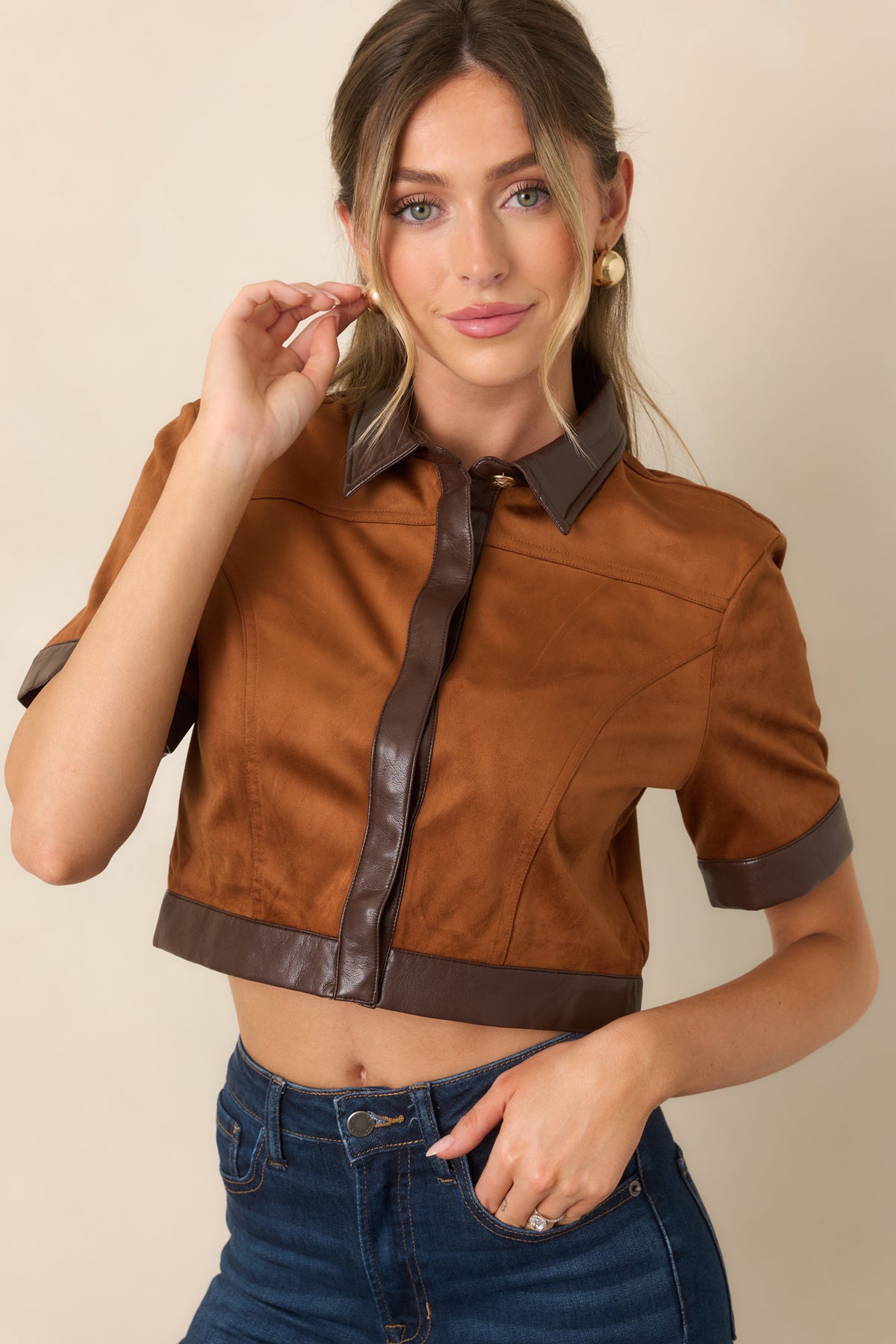 Warm camel faux suede top with contrasting brown trim framing the cropped hemline.