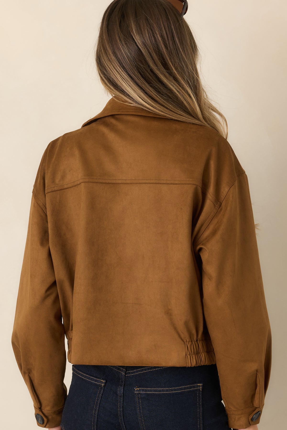 Camel faux suede cropped trench coat showcasing the elasticized hem and belted waist from the rear.