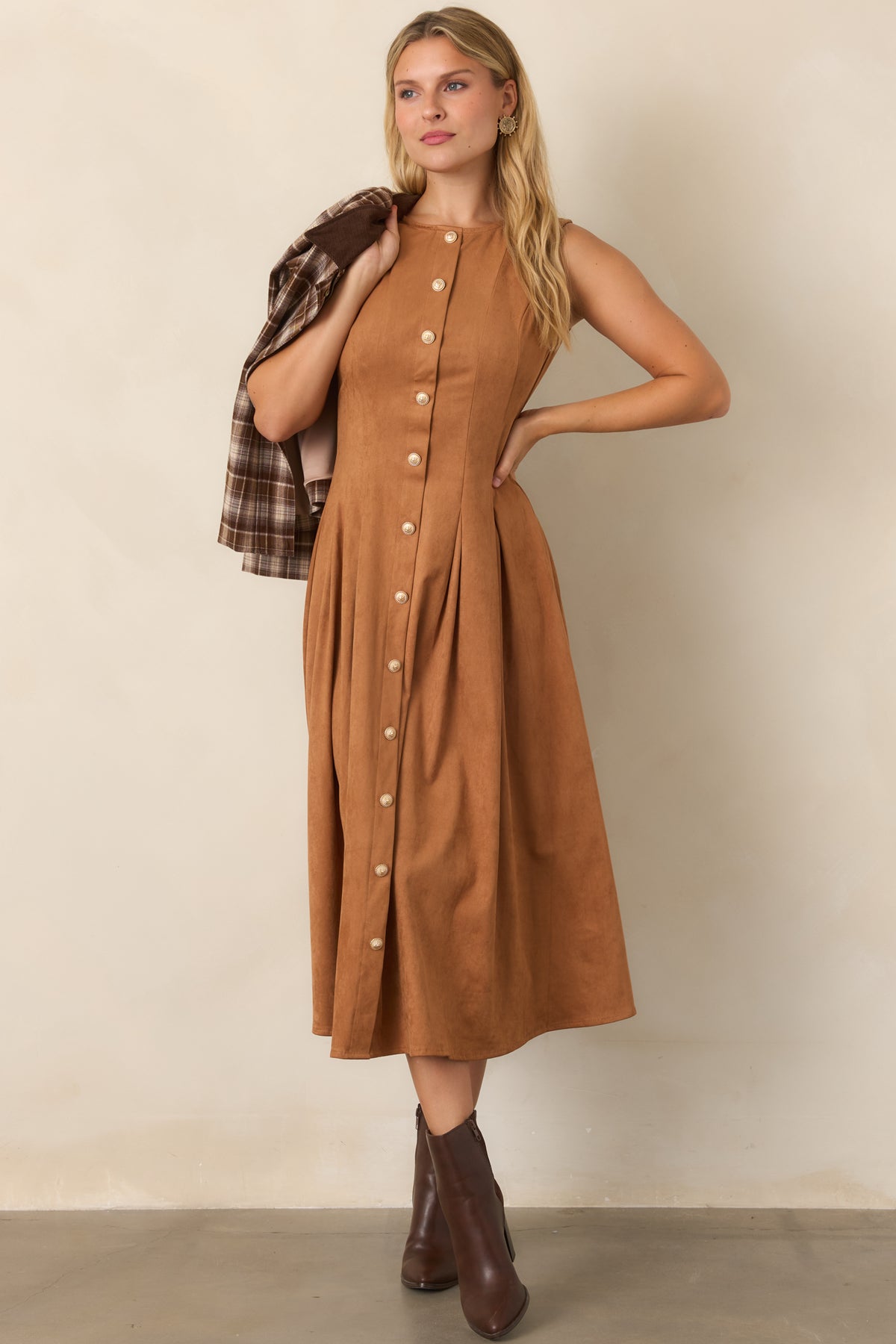 Soft camel faux suede dress with a fitted bodice, round neckline, princess seams, and flowing pleated midi skirt accented by gold-tone front buttons.