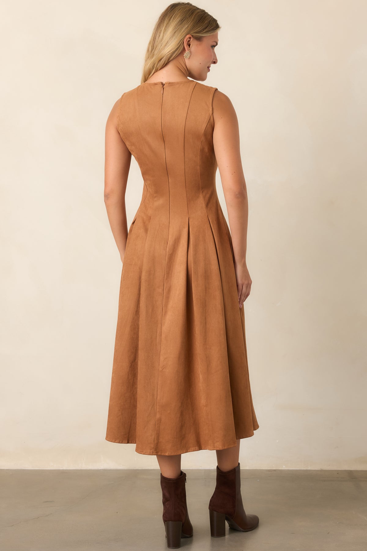 Rear of the camel faux suede midi dress showing the sleeveless fitted silhouette, smooth concealed zipper, and pleated skirt.