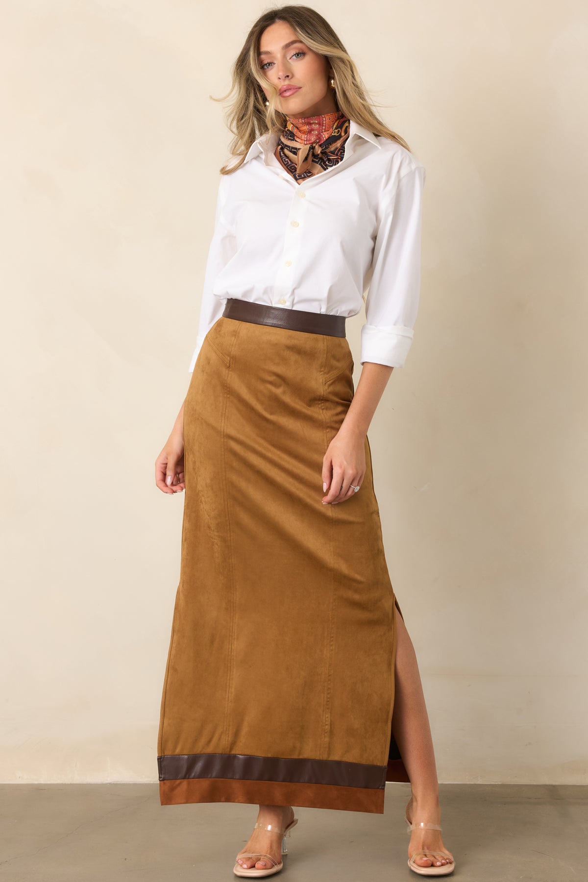 Camel faux suede skirt featuring vertical seam detailing, contrast waistband trim, and a floor-length silhouette.
