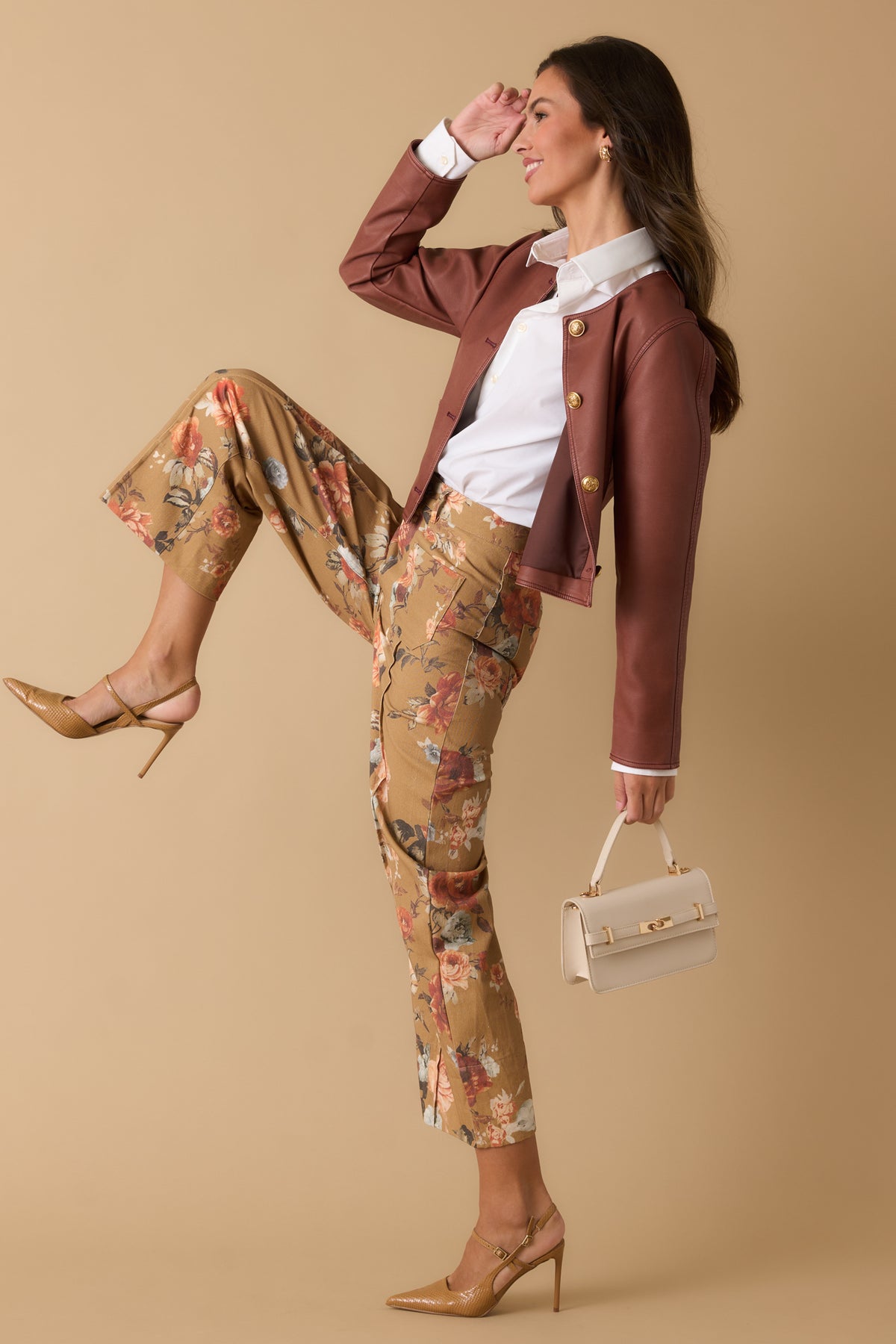 Warm camel pants featuring vintage-style floral blooms, a high-rise waist, relaxed wide-leg silhouette, and pressed front seams.

