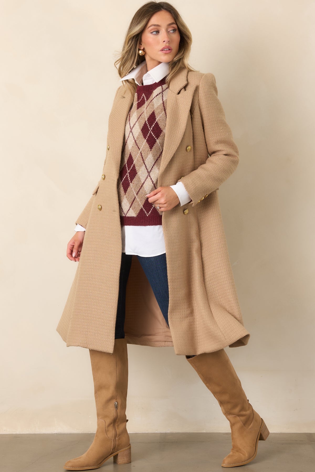 Gold-tone button closures accent the tailored camel topcoat, finished with long sleeves and notched lapels.
