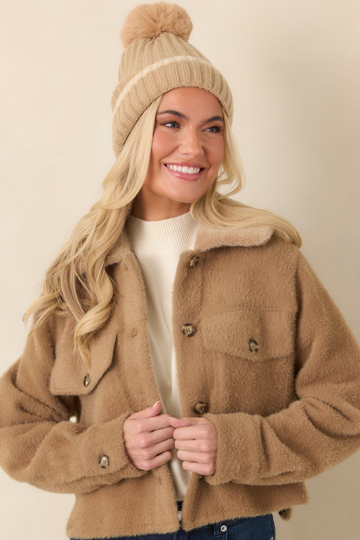 Two buttoned flap chest pockets add utility-inspired detail to the camel jacket front.