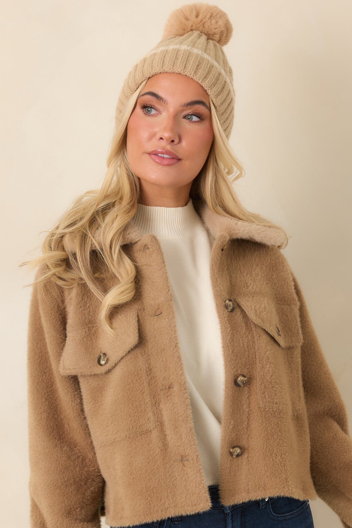 Long camel jacket sleeves finish with adjustable buttoned cuffs and visible tonal stitching.