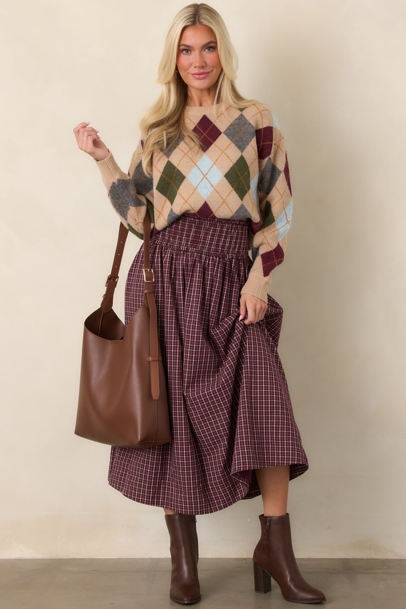 Camel sweater featuring a multicolor diamond pattern in burgundy, olive, grey, light blue, and warm golden tones, with a crew neckline and relaxed fit.