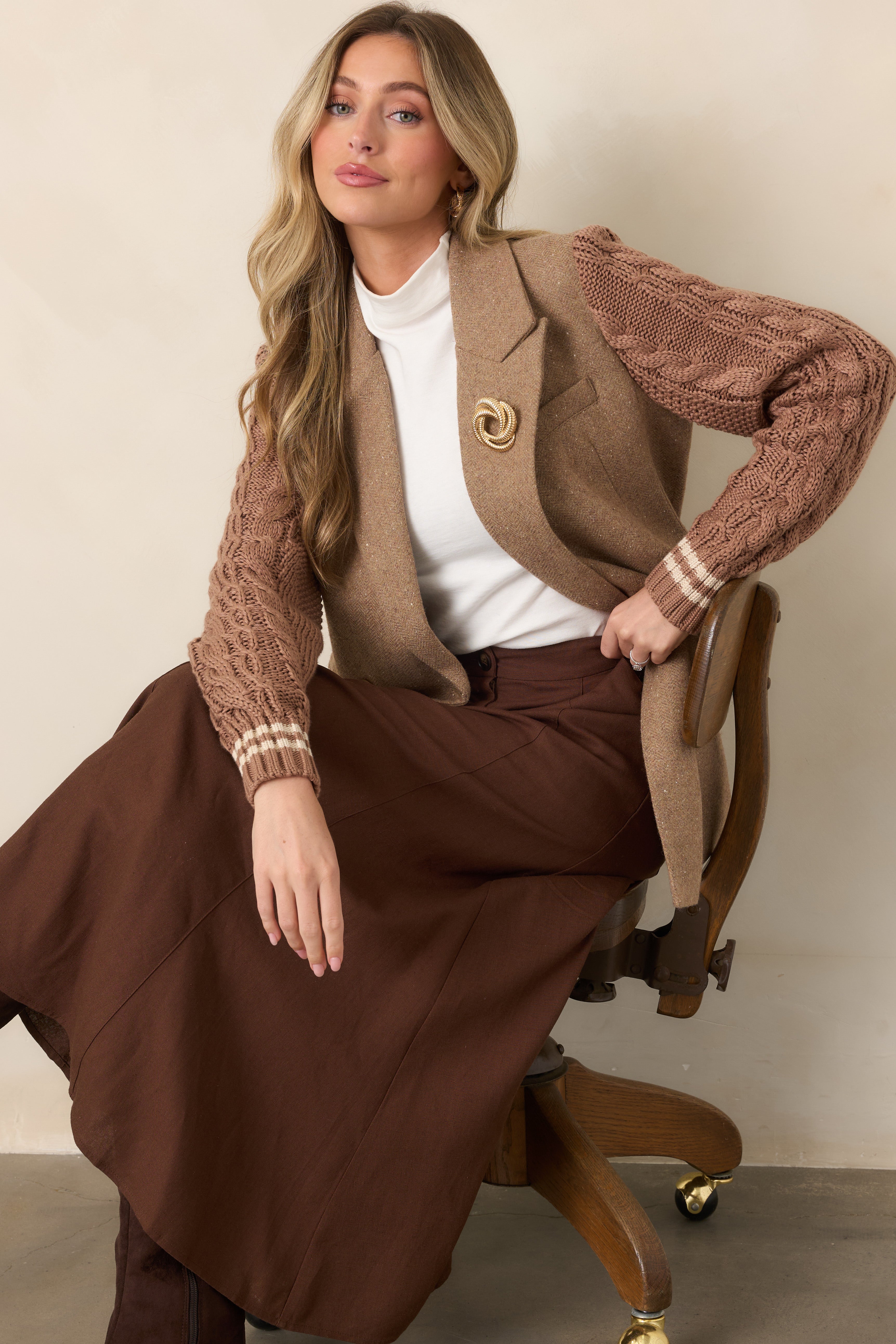 Camel wool-blend blazer with a structured double-breasted front, notched lapels, flap pockets, and contrasting cable-knit sleeves.