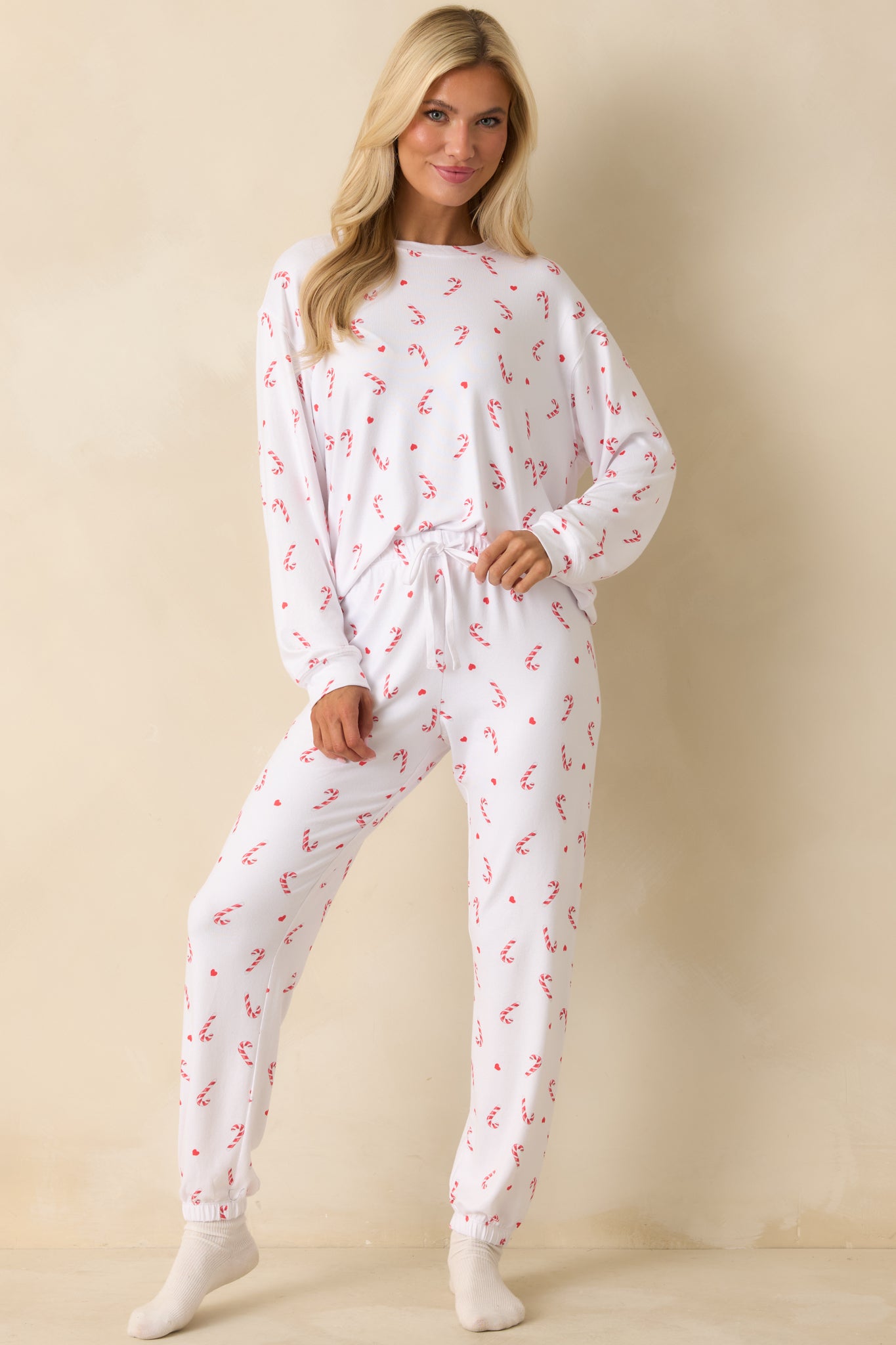 Candy-cane print white top with a soft drape and classic crew neckline for a cozy, holiday-ready look.