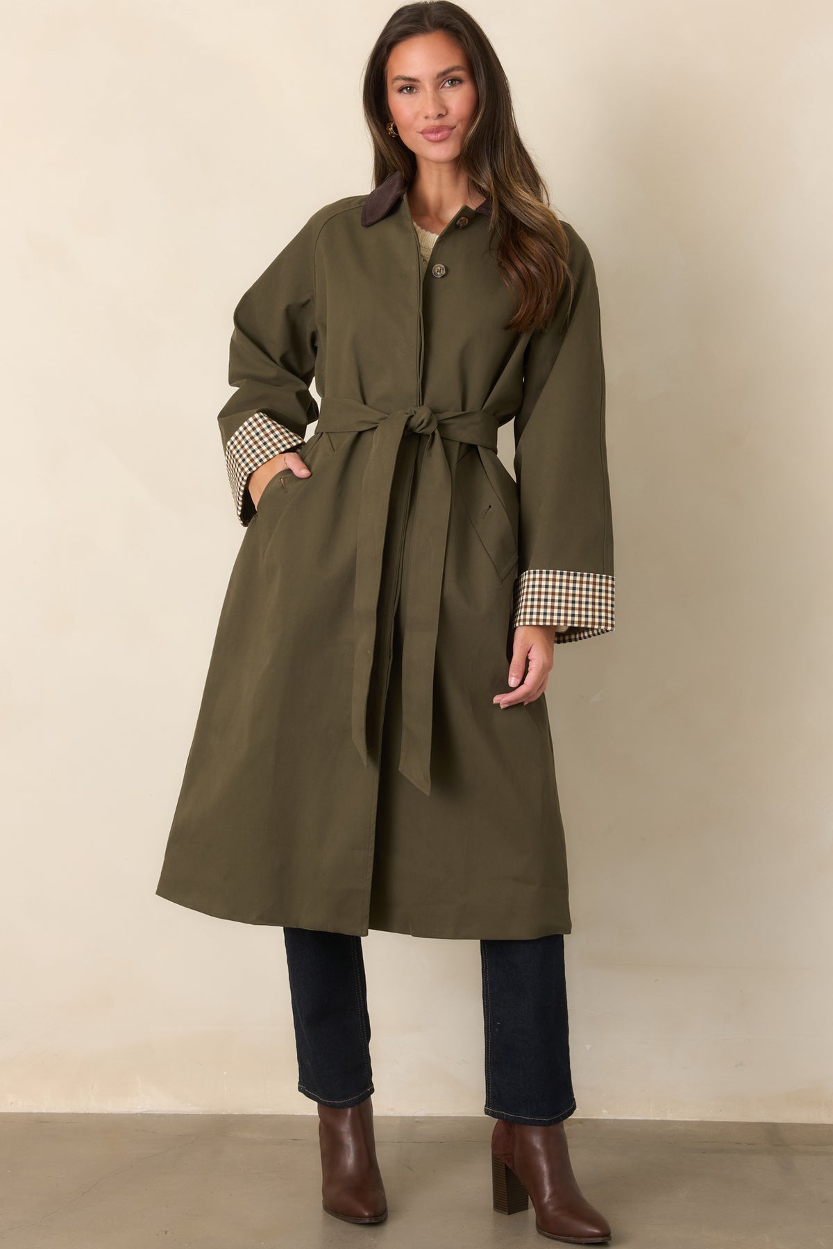 Smooth canvas-feel coat featuring a button front, waist-defining tie belt, and functional side pockets.