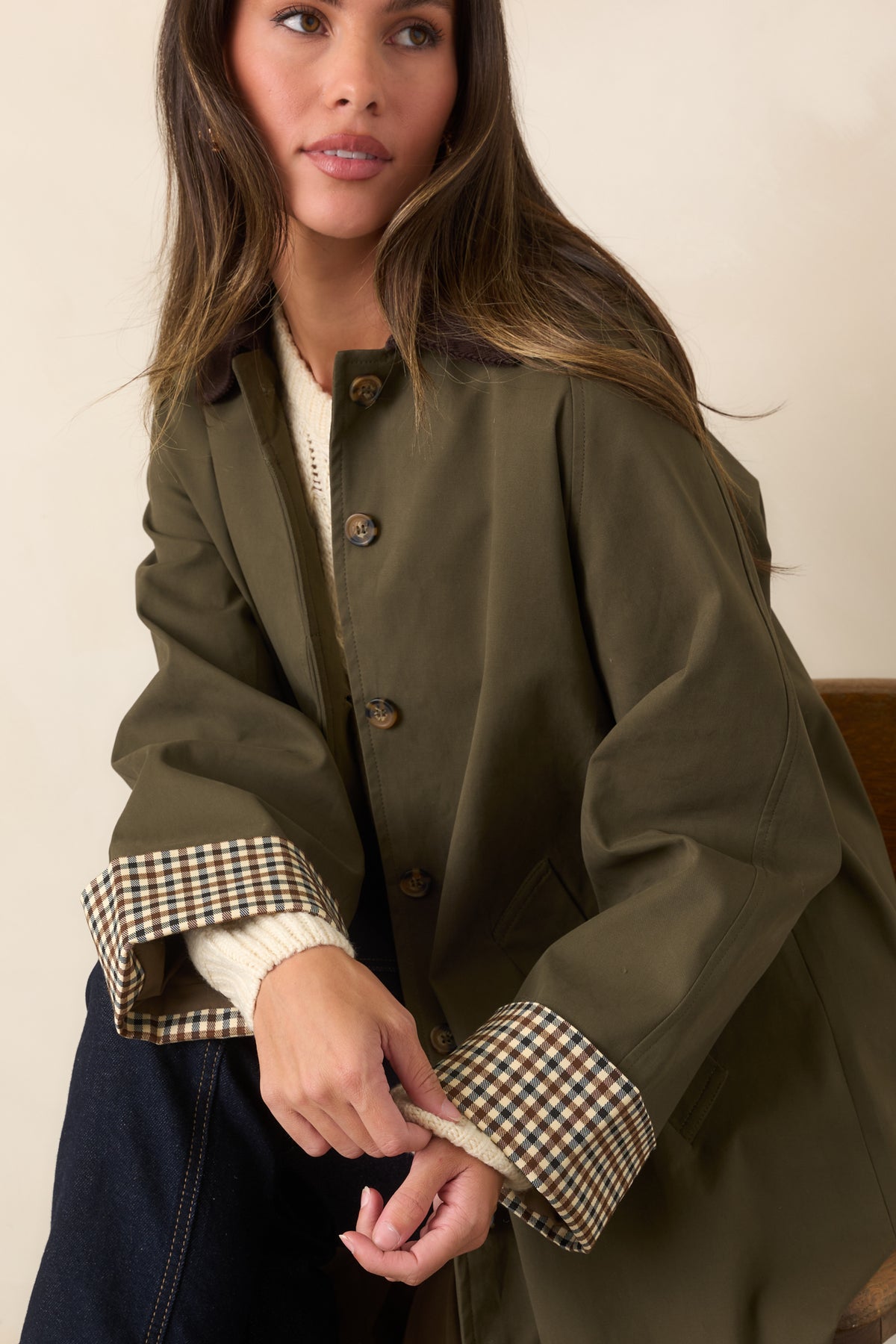 Canvas-feel coat highlighting its chocolate corduroy collar, checked cuffs, and defined waist.
