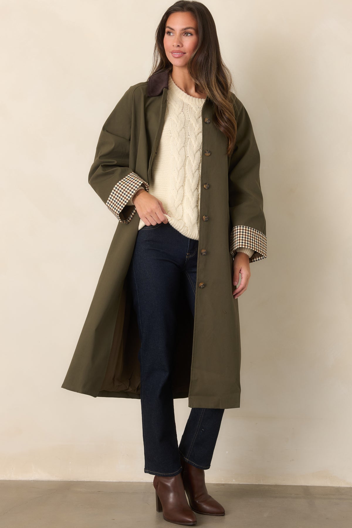 Coat with a smooth canvas-feel finish, coordinating tie belt, functional side pockets, and button-front closure.
