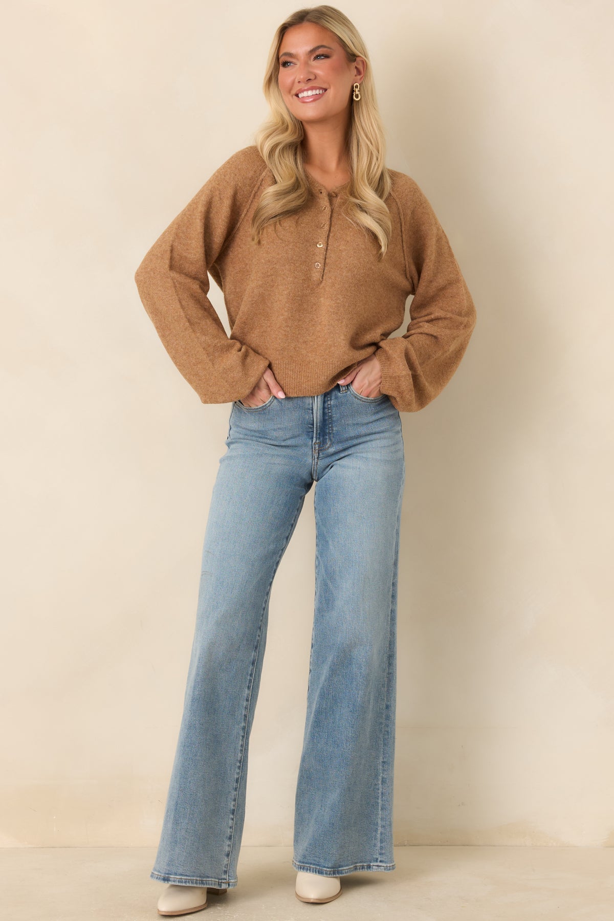 Caramel brown midweight knit top featuring a Henley neckline, tonal button placket, long raglan sleeves, and a slightly cropped silhouette.