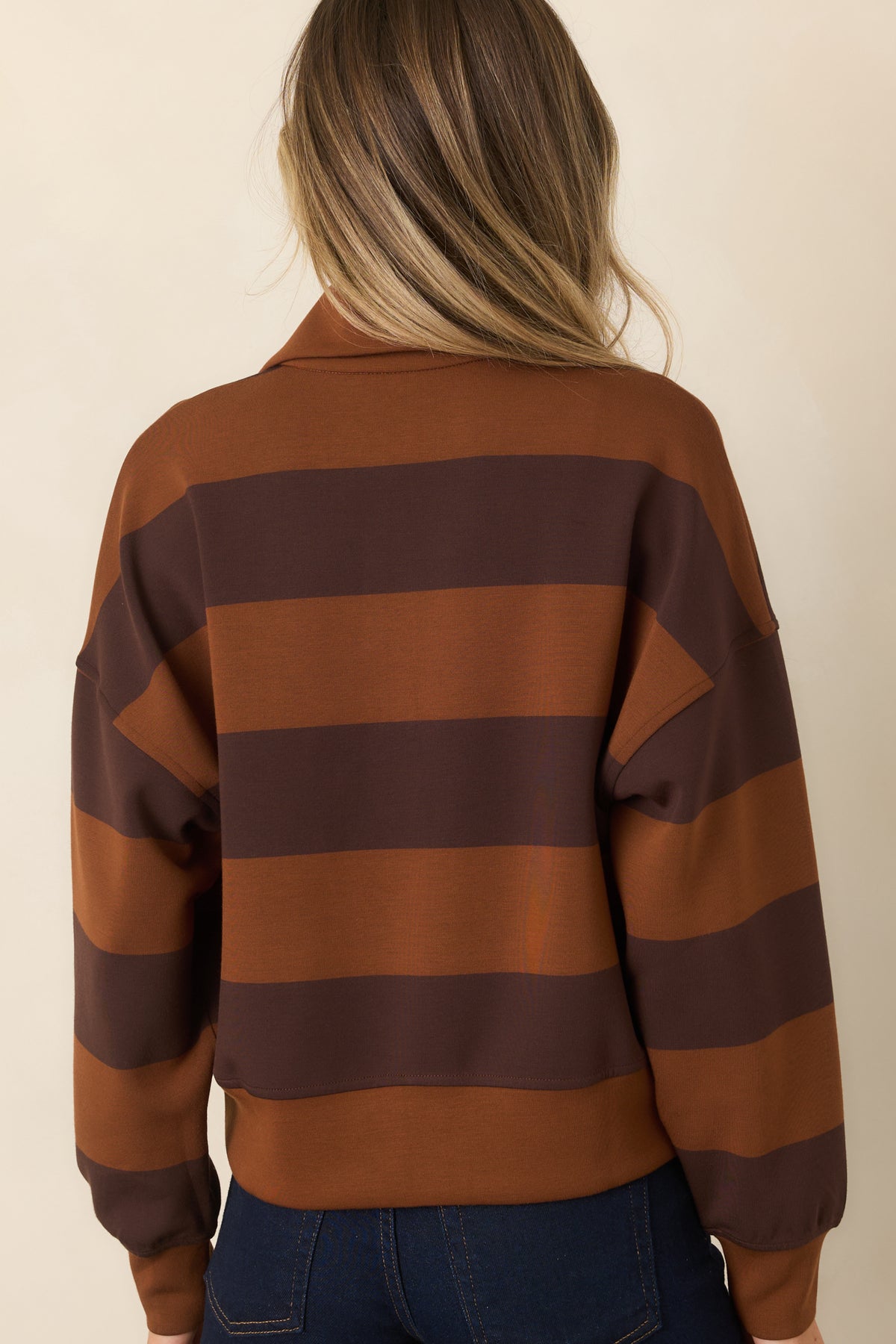 Rear of the striped spacer fabric top showing the dropped shoulders, long sleeves, relaxed fit, and banded hem.
