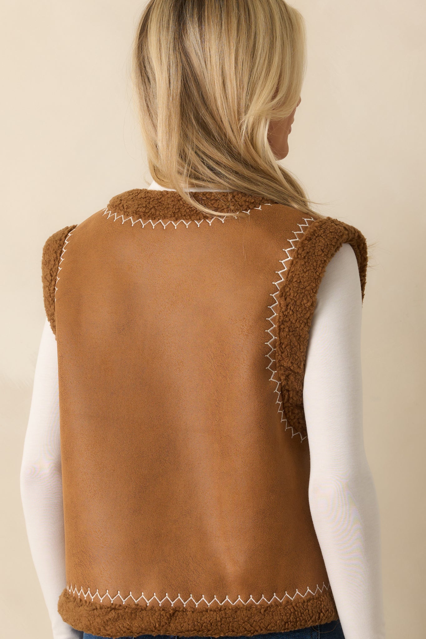 Rear view of caramel brown vest showing straight hem, sleeveless design, and smooth faux suede finish.