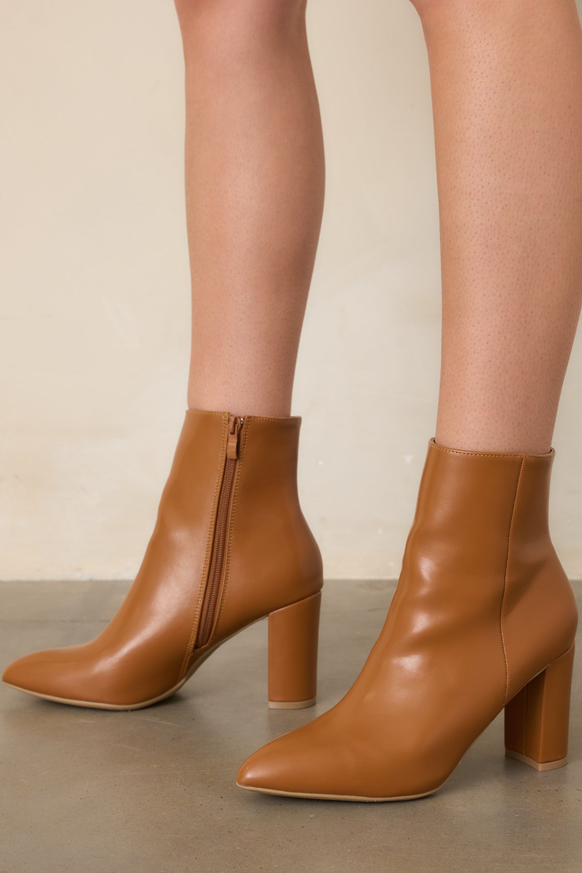 Caramel faux leather ankle boot showcasing the outer seam detailing and structured ankle shaft.