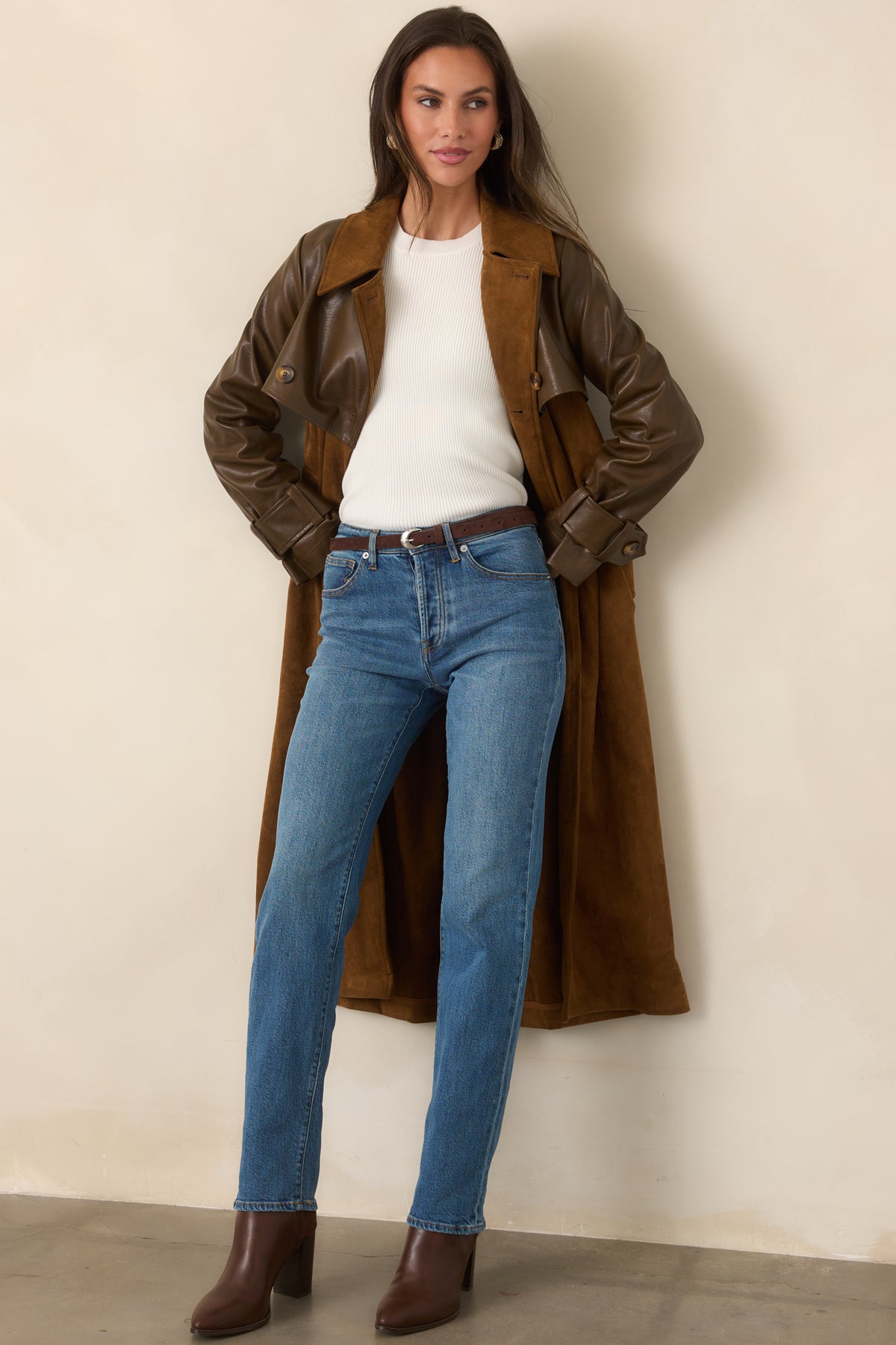 Classic long trench styling pairs a warm caramel body with contrasting brown faux leather sleeves and button-tab cuffs.