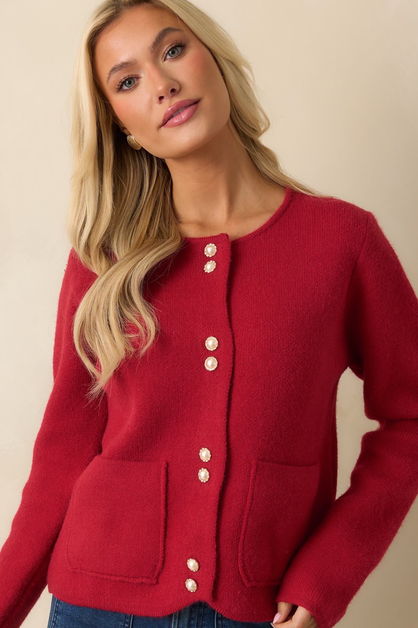 Detailed view of the cardigan’s button closure and medium-weight knit fabric.