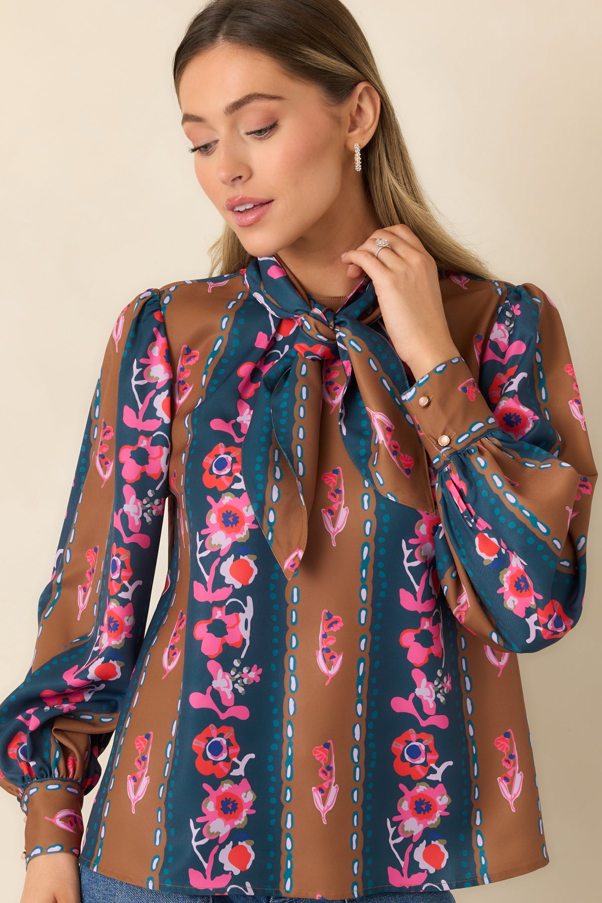 Delicate chain-like and dotted motifs complement the colorful floral pattern across the striped blouse.