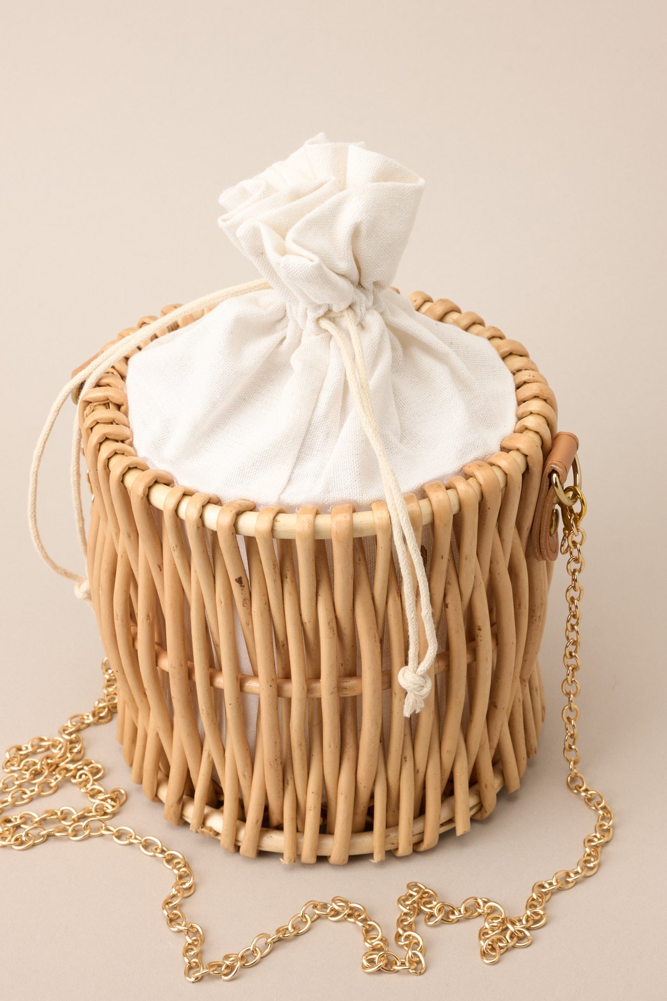 Cropped image focusing on chain strap and drawstring closure at top of bag.