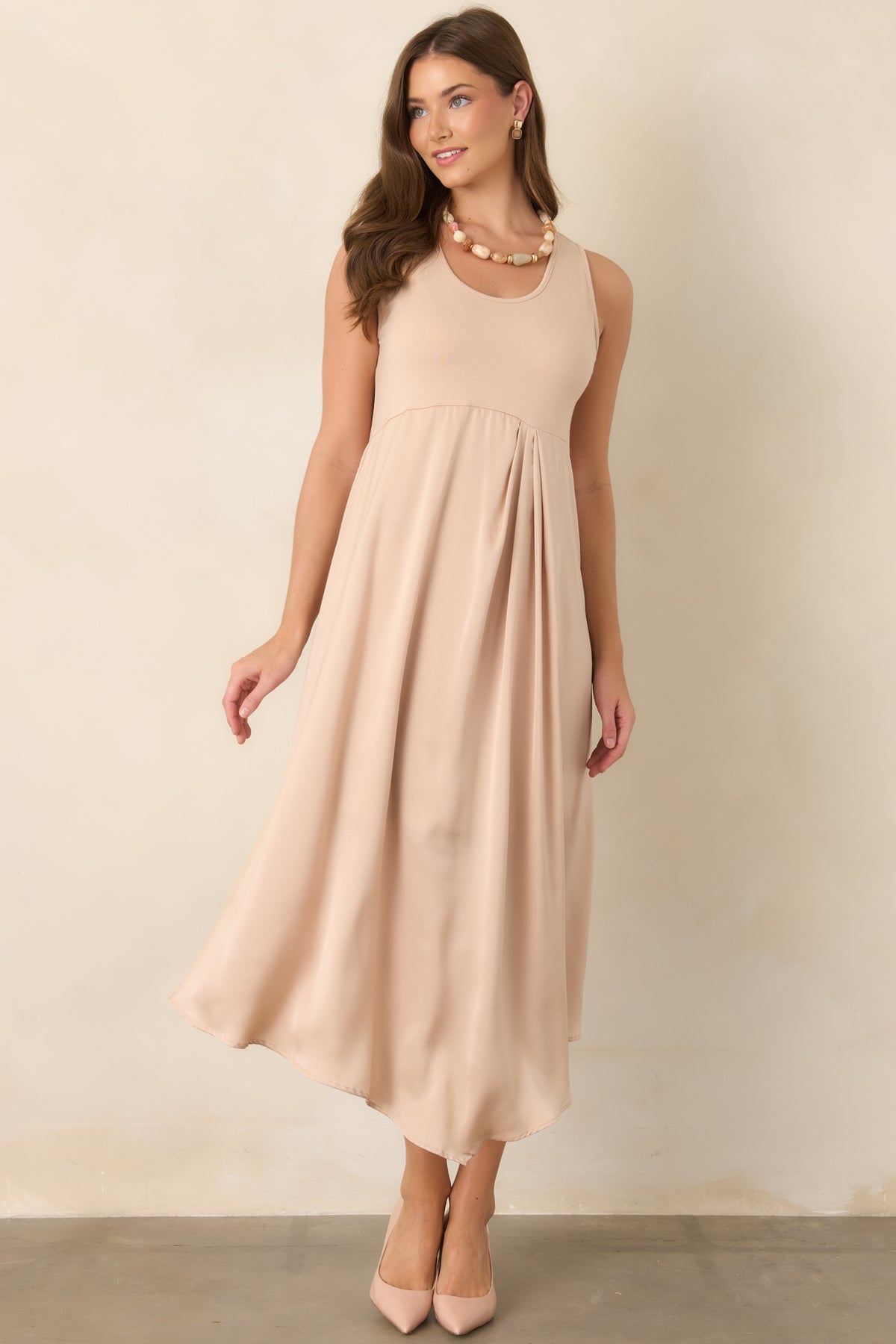 Soft champagne midi dress combining a stretch-knit sleeveless bodice with a lustrous satin skirt and graceful scoop neckline.