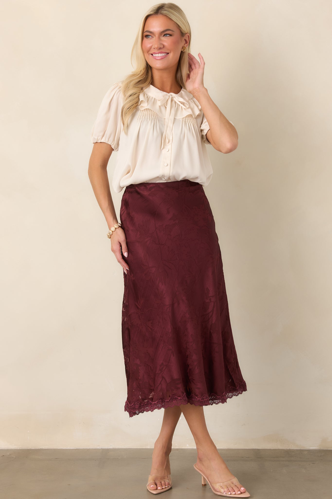 Champagne cropped blouse featuring a wide ruffled collar, delicate tie neckline, covered button front, short puff sleeves, and softly gathered silhouette.