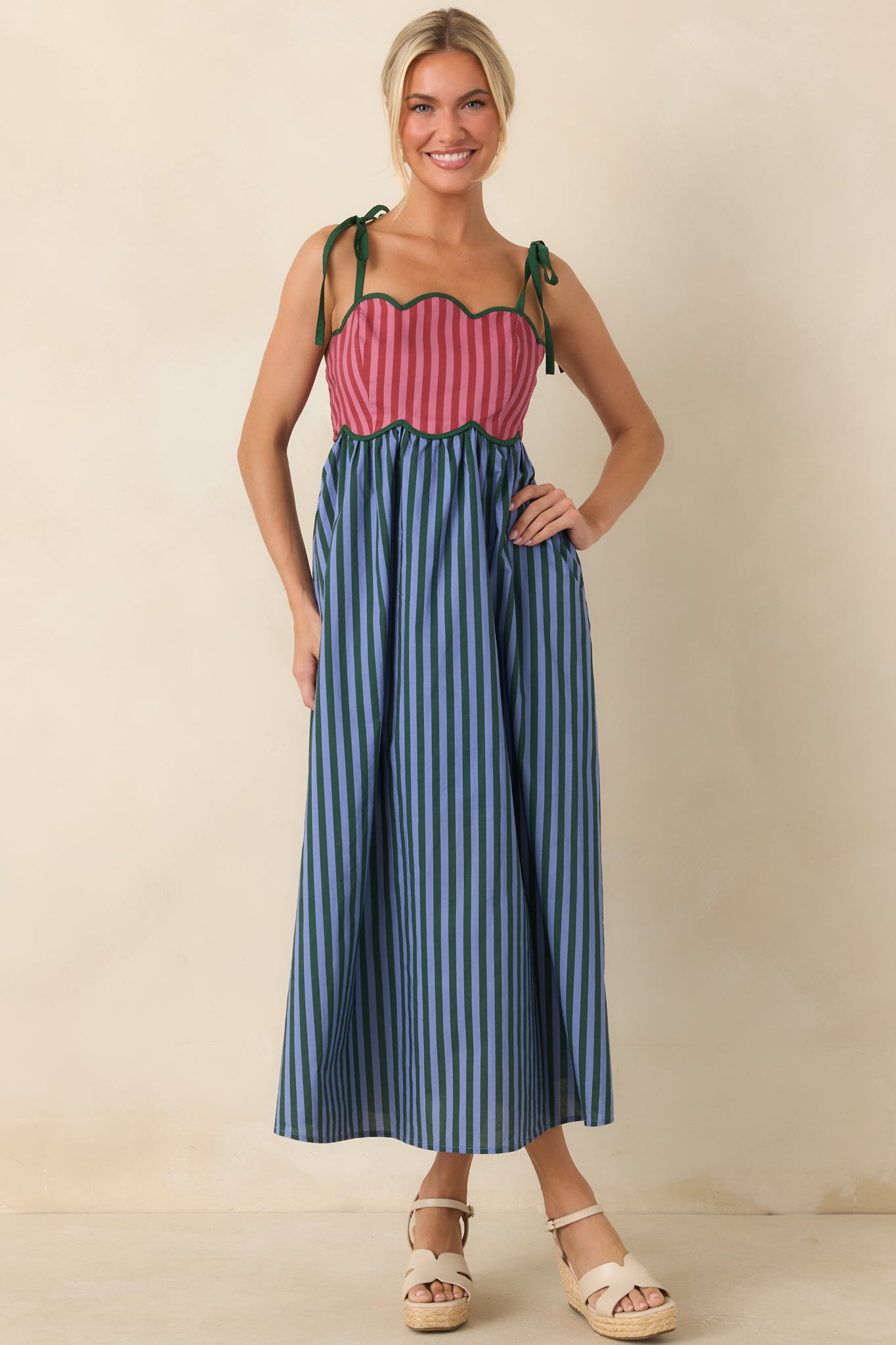 Charming gathered midi dress featuring a lined cotton construction, contrast trim, and a vibrant striped pattern.