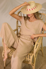 This beige top featuring a cap sleeve design, a crew neckline, slightly cropped length, and breezy lightweight fabric. 