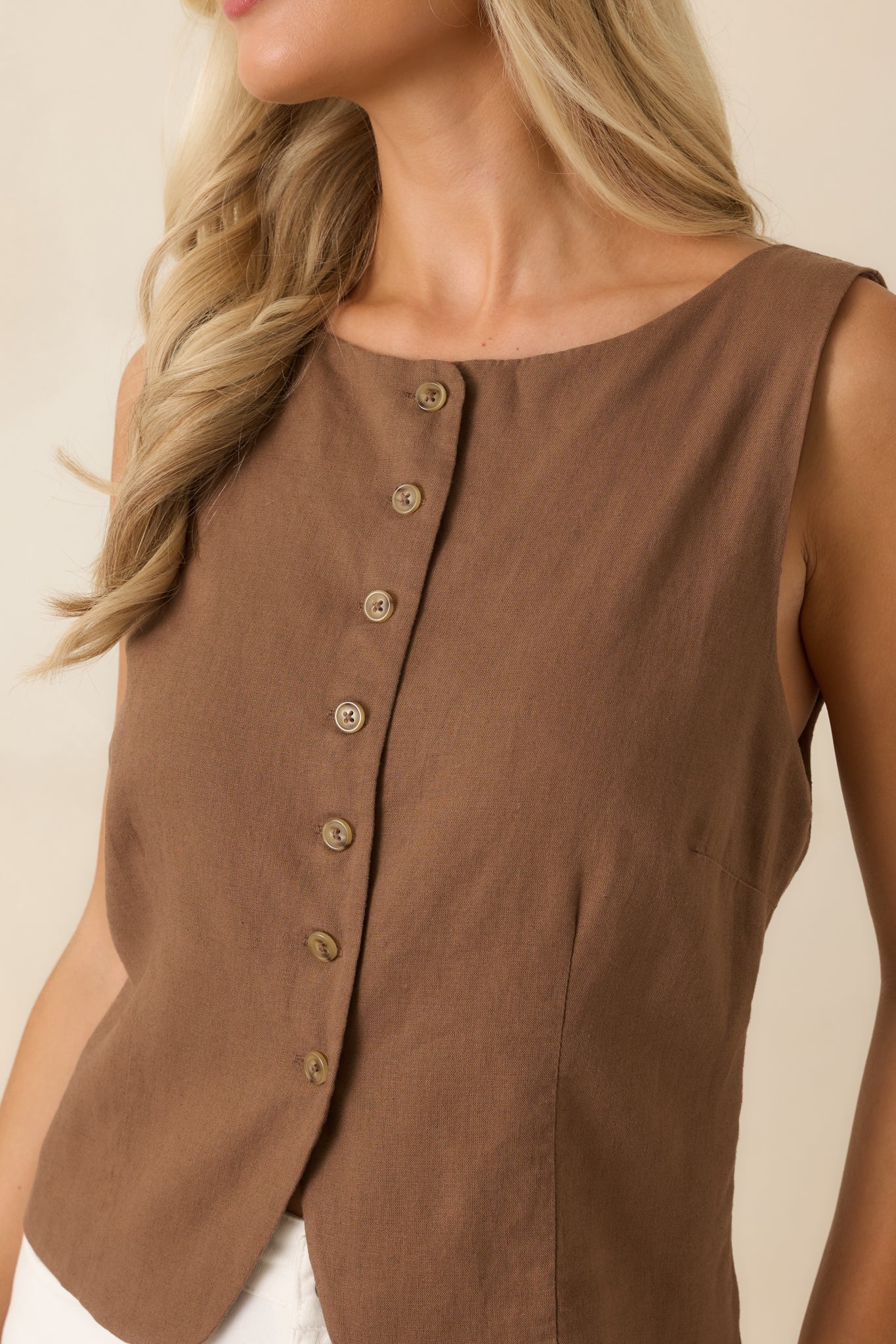 Detailed view of the chestnut brown vest highlighting the button-front closure, neckline, and precise seam detailing.