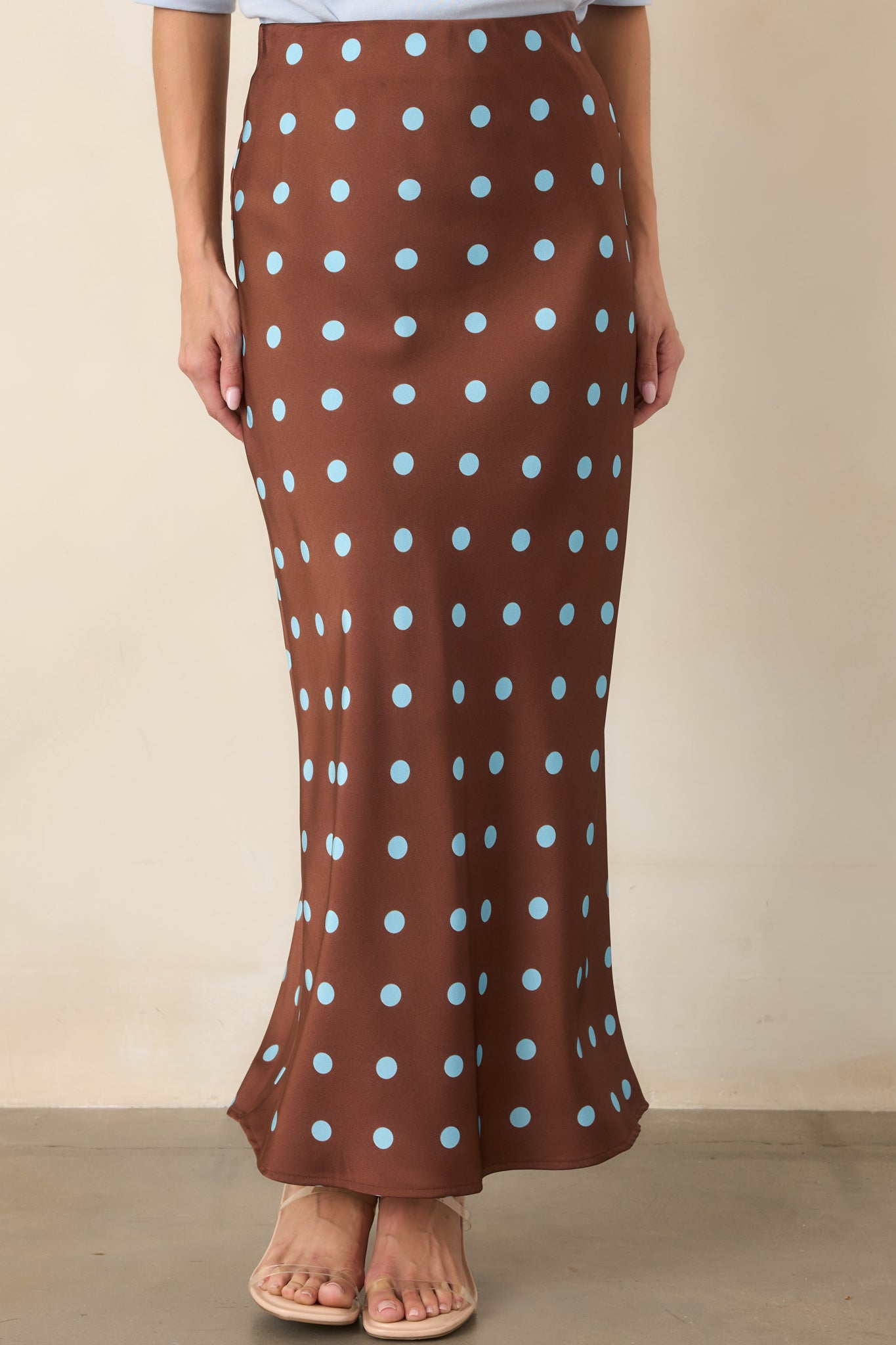 Chocolate brown polka dot skirt emphasizing the graceful drape and softly angled lines created by its bias-cut silhouette.