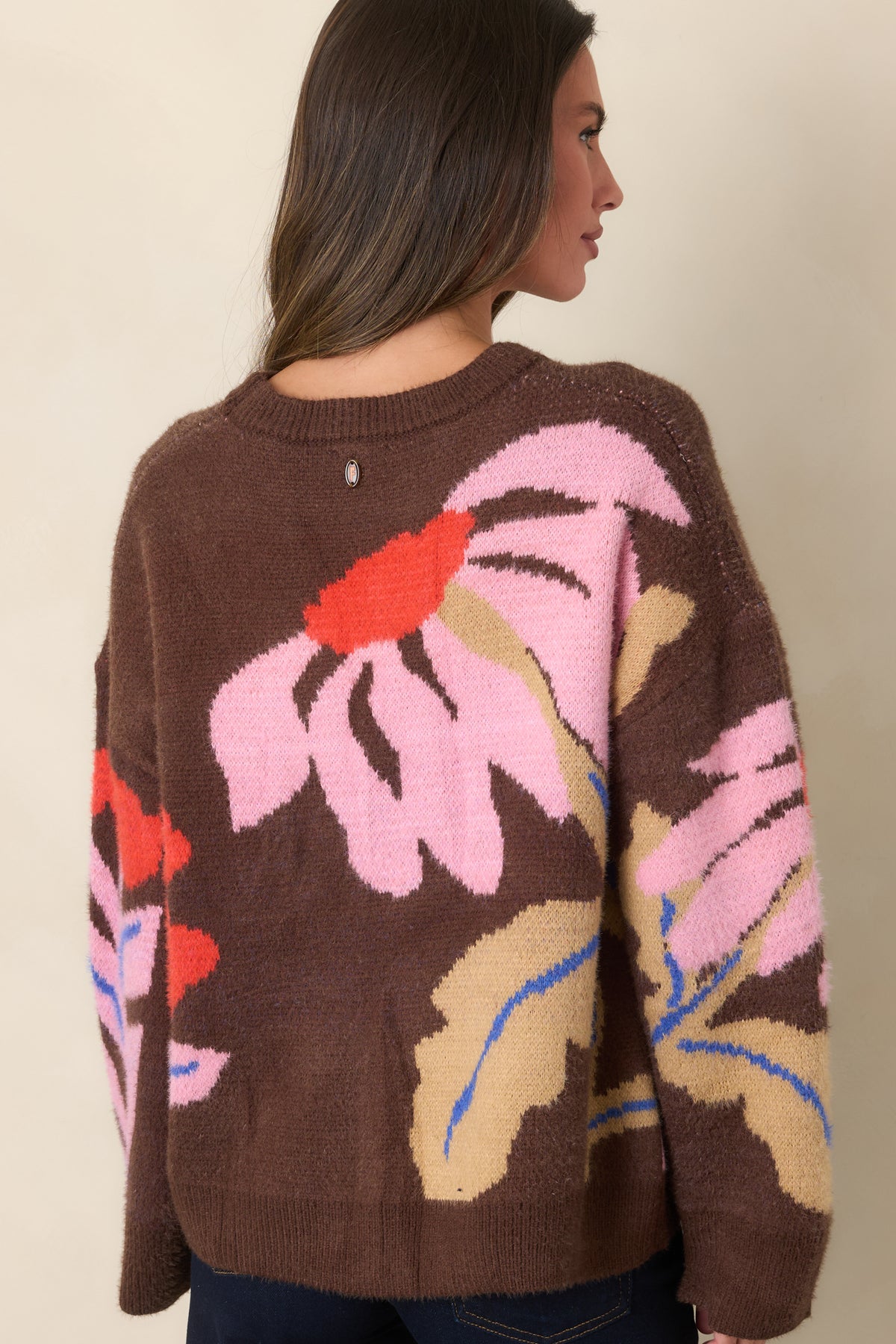 Rear view of the chocolate-brown knit top showing the botanical intarsia design continuing across the back and sleeves.