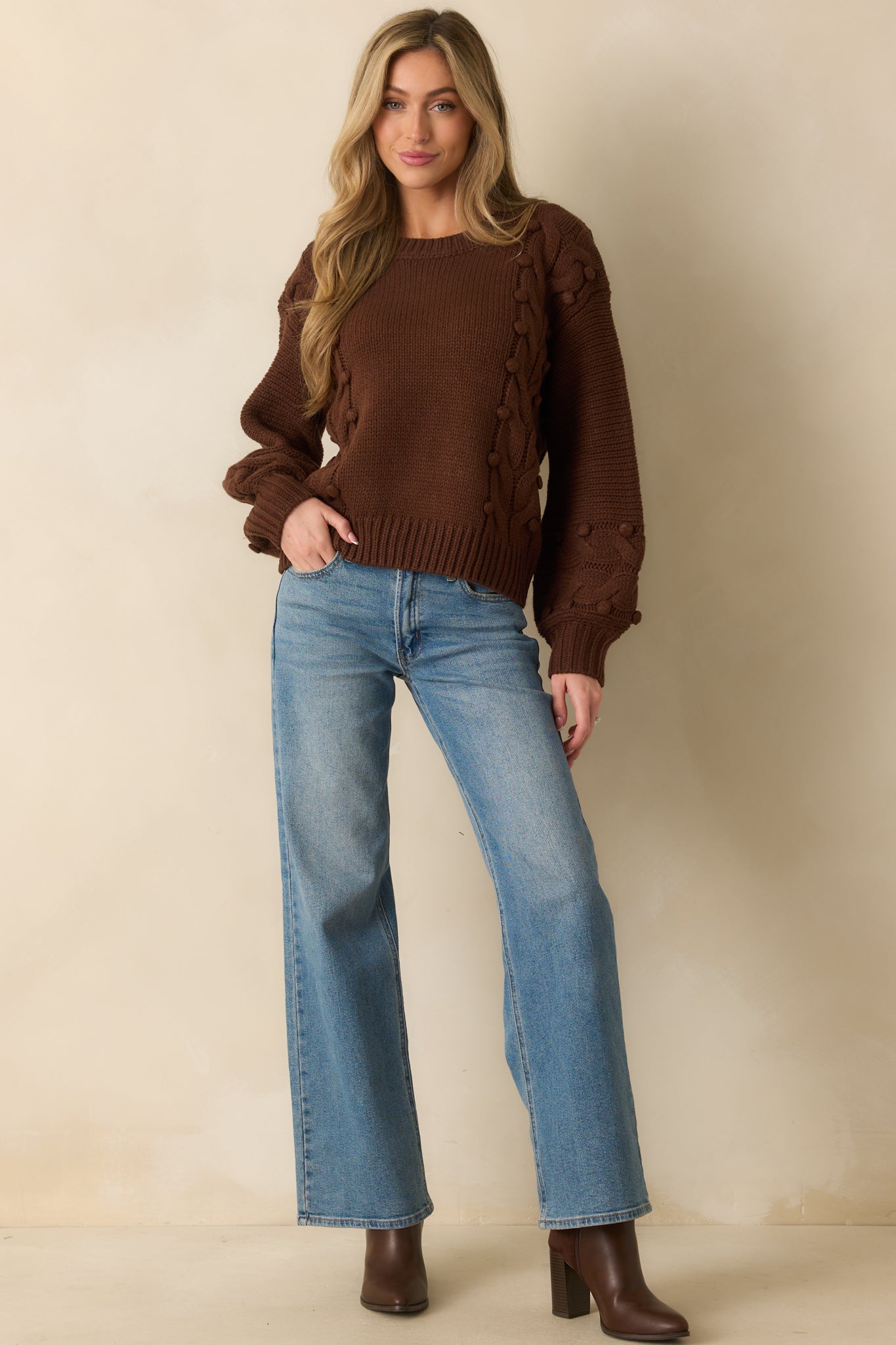 Chocolate brown sweater with chunky cable knit design and a crew neckline.