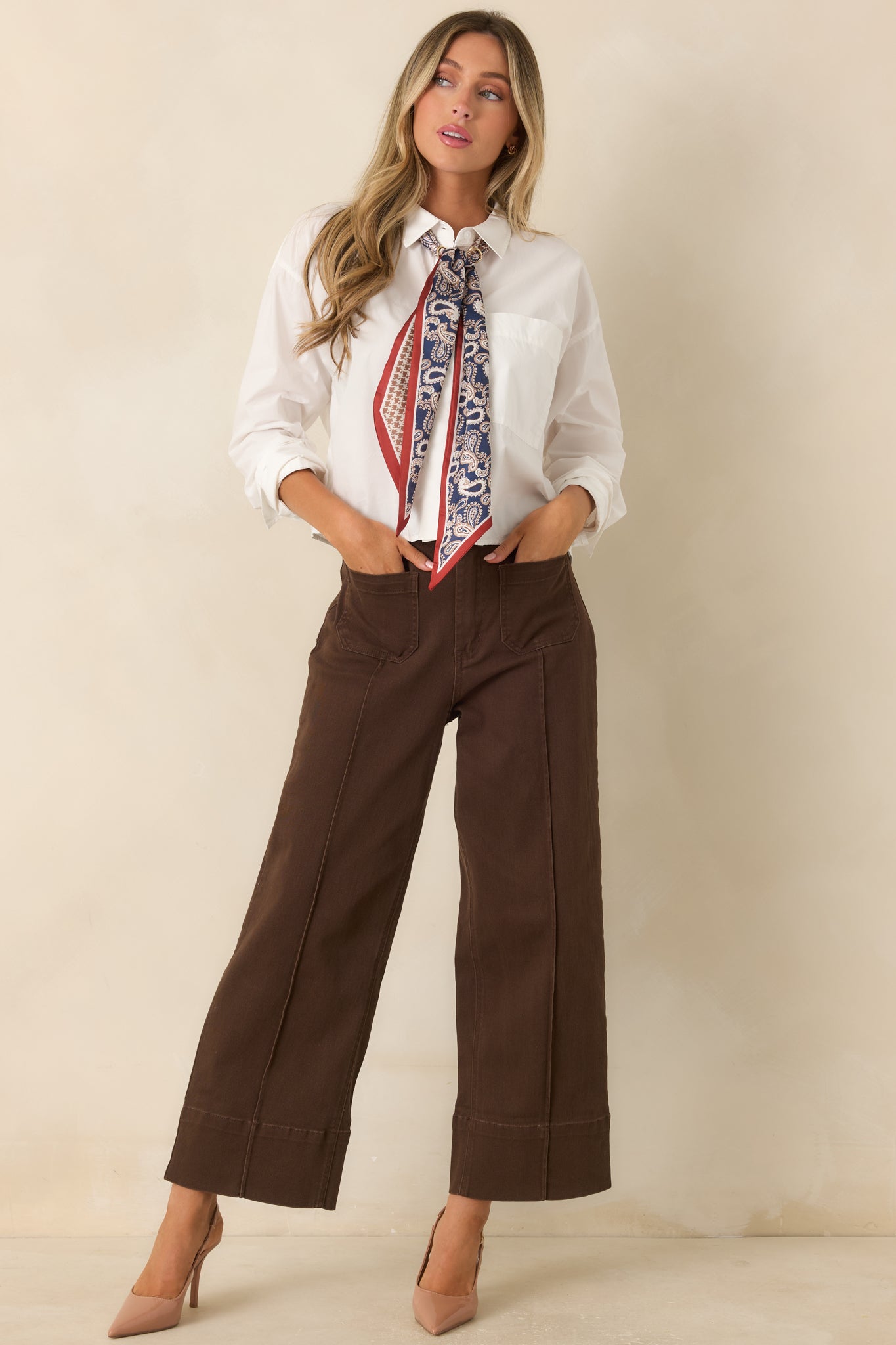 Chocolate brown cropped wide-leg pants featuring a high-rise waist, oversized front patch pockets, pressed center seams, and wide cuff hems.