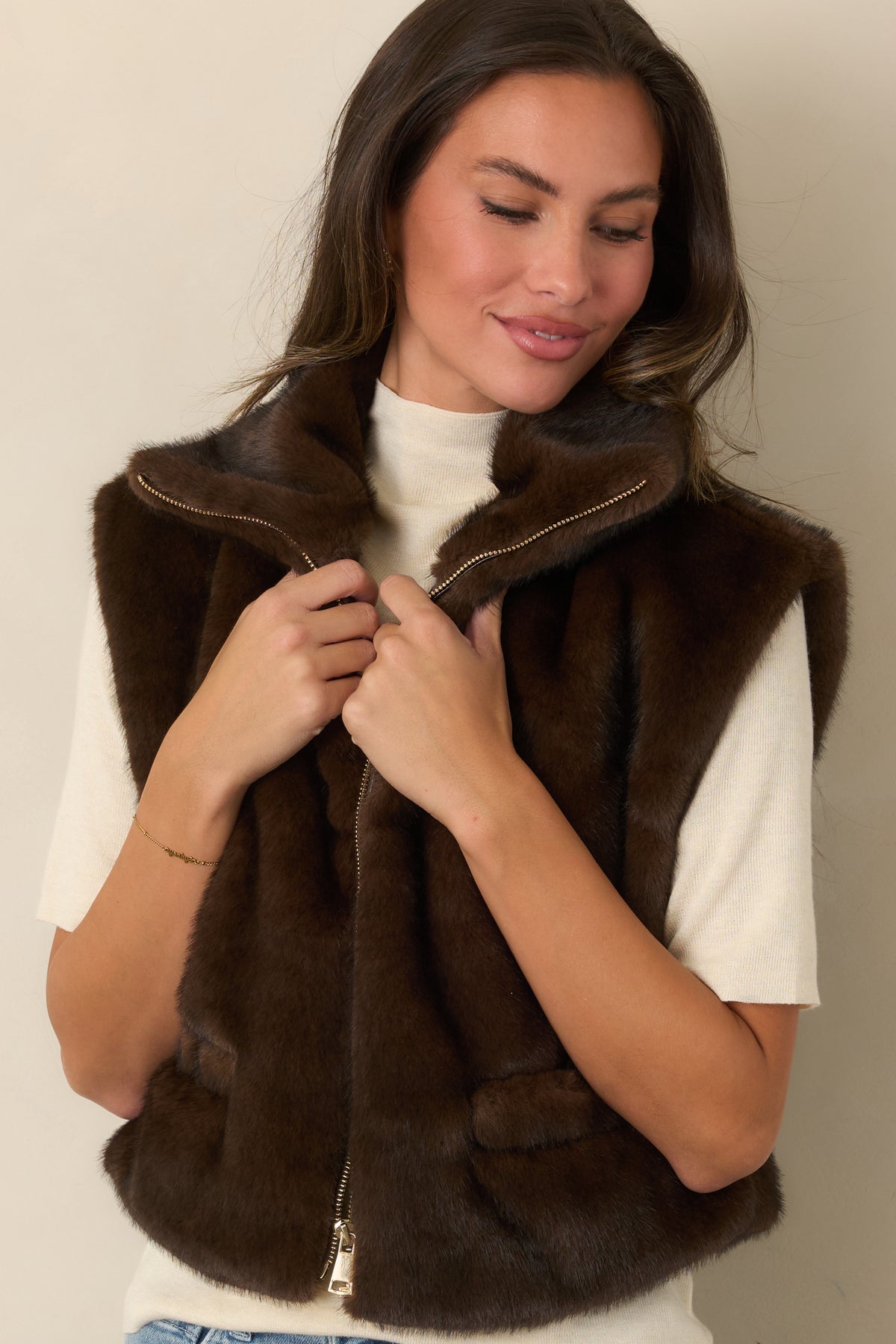 Oversized collar and silver-tone zipper define the front of this chocolate brown faux fur vest.