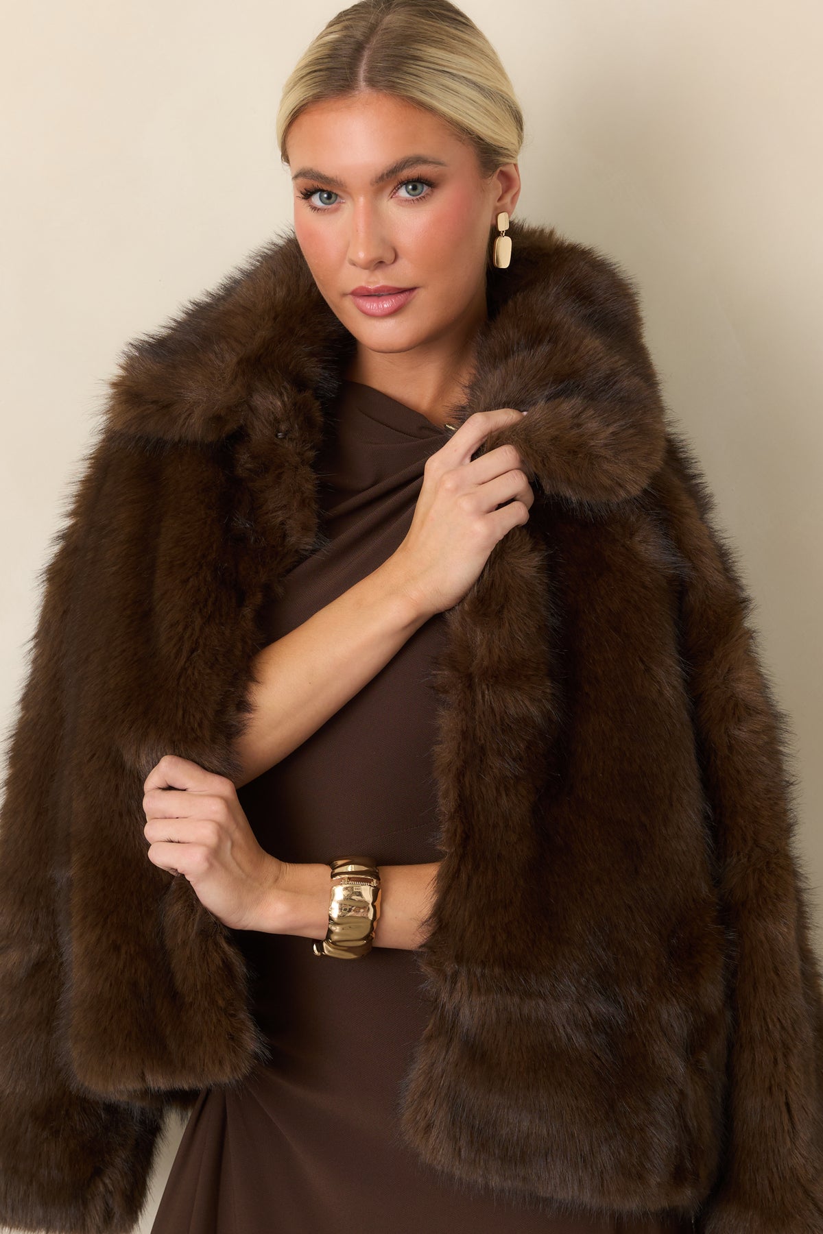 Chocolate brown faux fur jacket highlighting its plush texture, generous collar, and front hook closures.