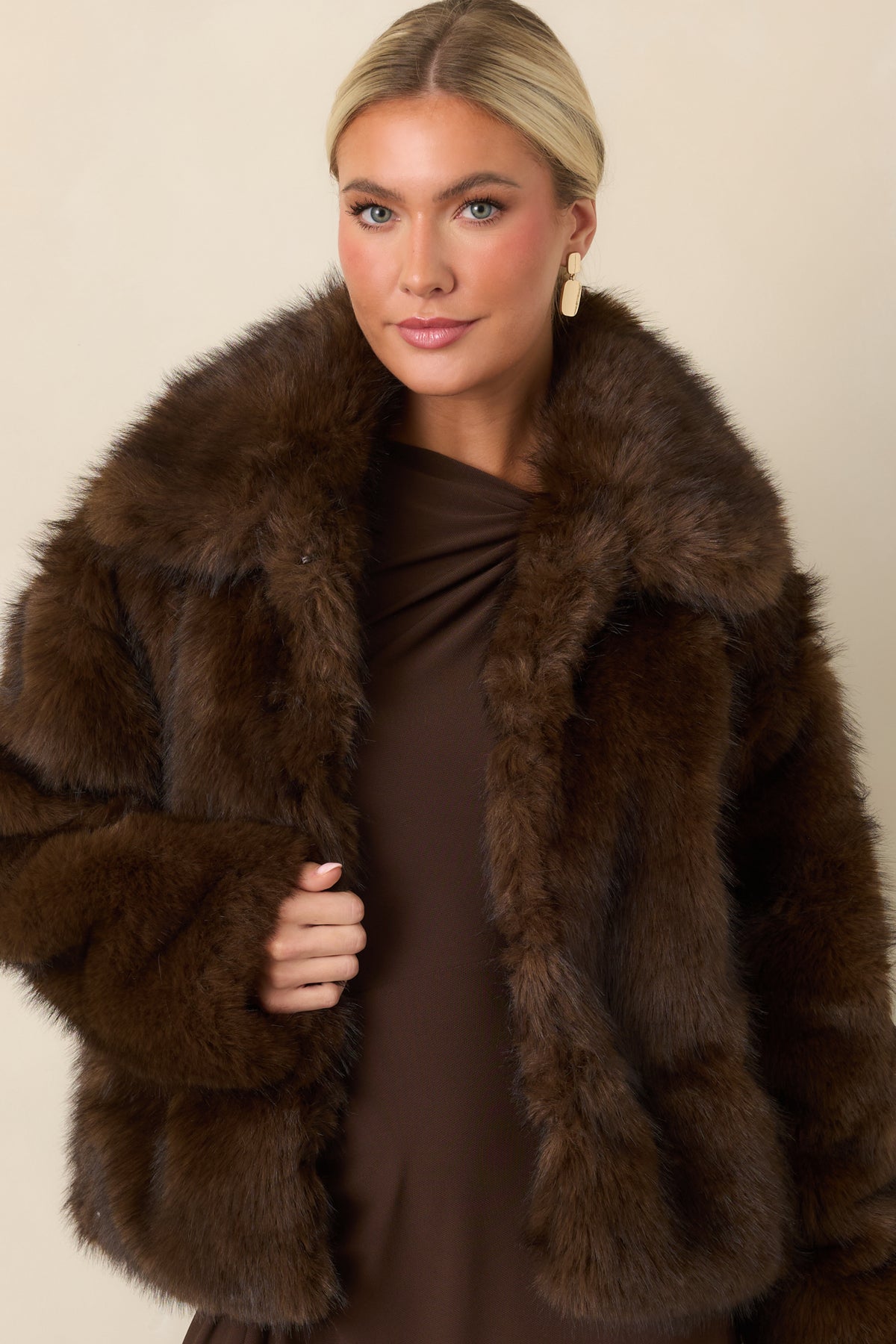 Chocolate brown faux fur jacket displaying the front hook closures and plush construction.