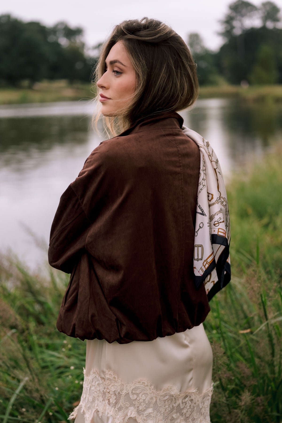 Rich chocolate brown faux suede bomber with dropped shoulders and a softly gathered elasticized hem.