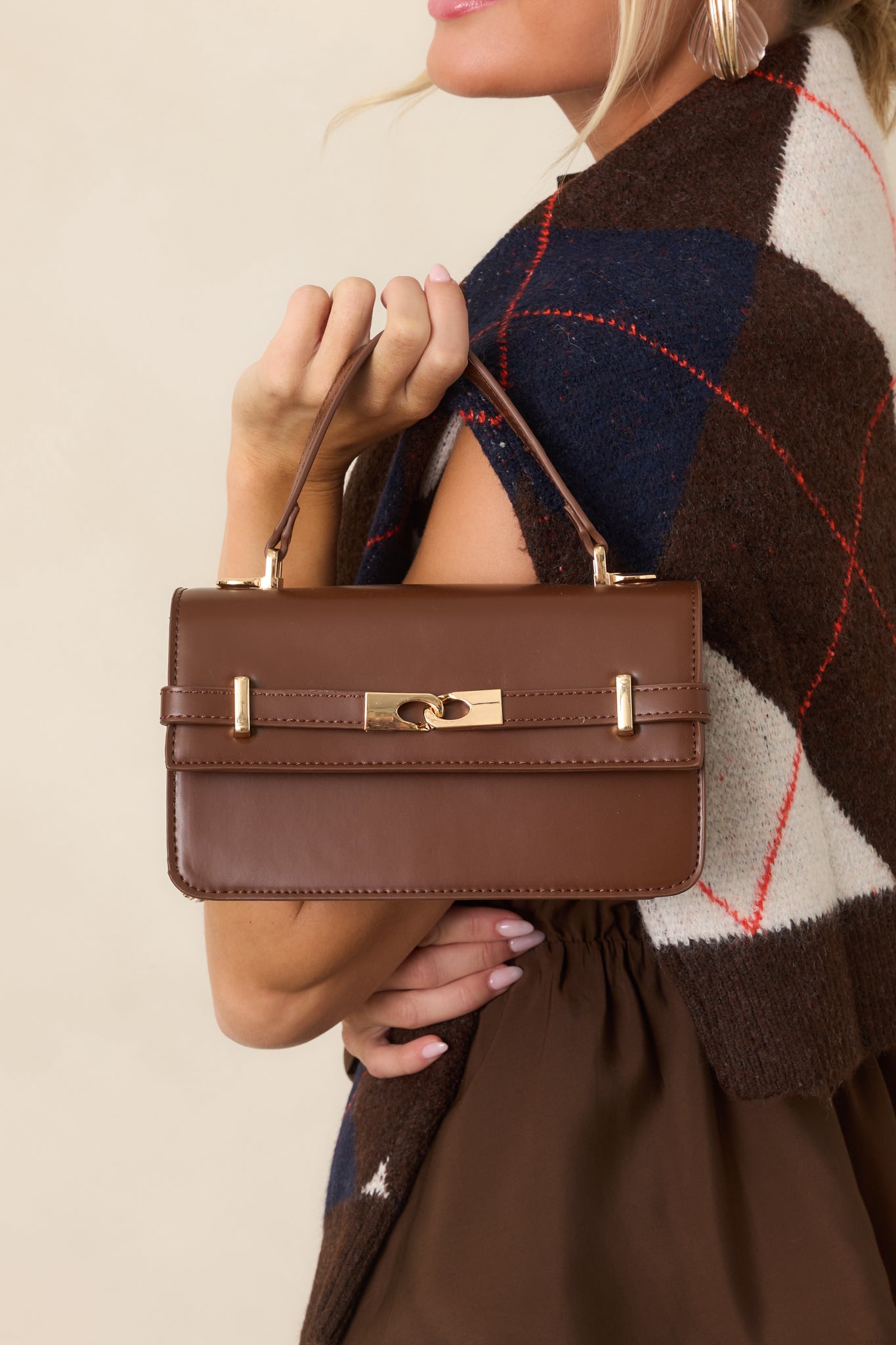 Close-up highlights the smooth faux leather, polished gold-tone hardware, and chic front belt detail.