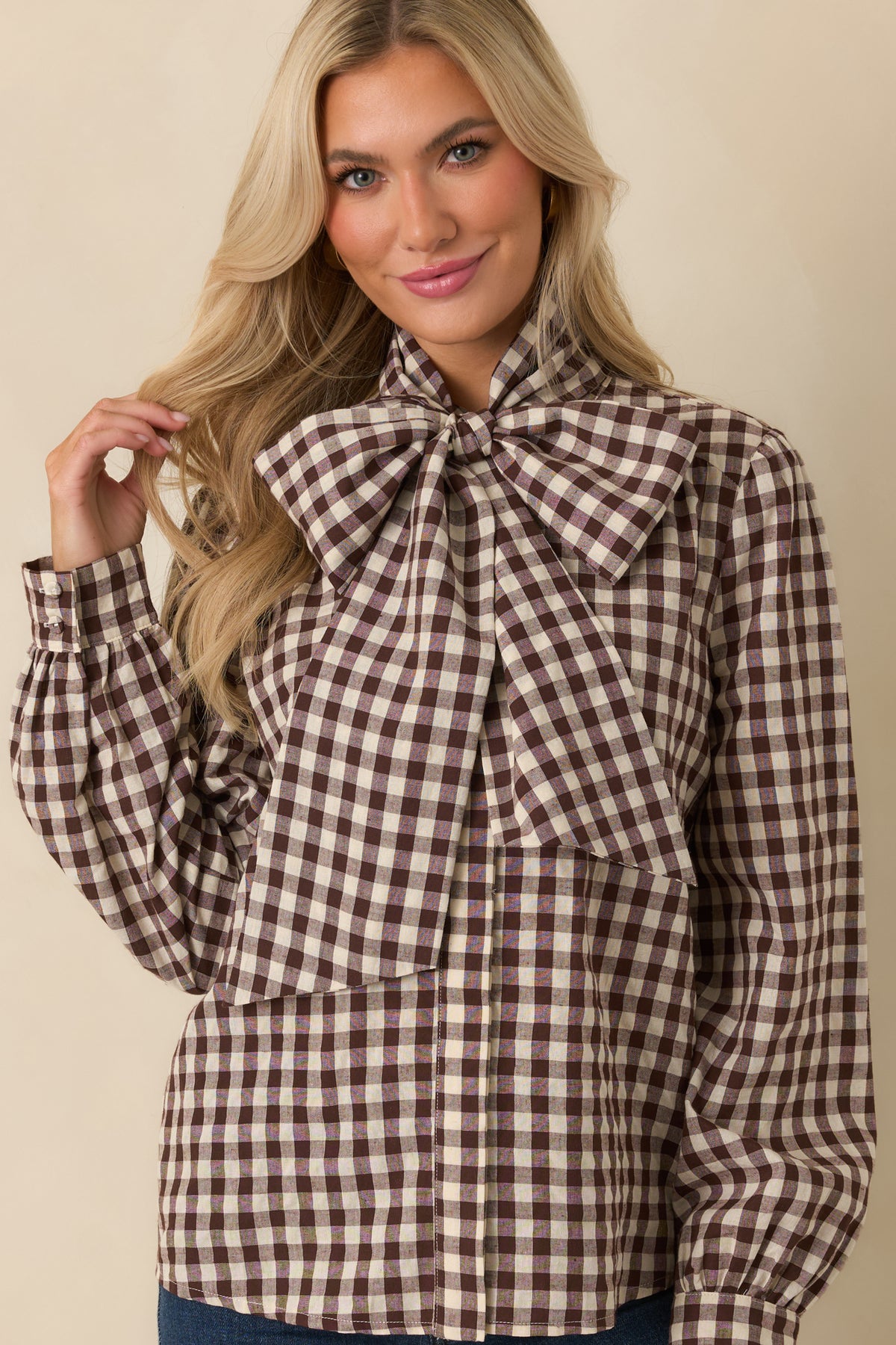 Chocolate brown and ivory gingham blouse with an oversized bow neck tie, long sleeves, and relaxed silhouette.