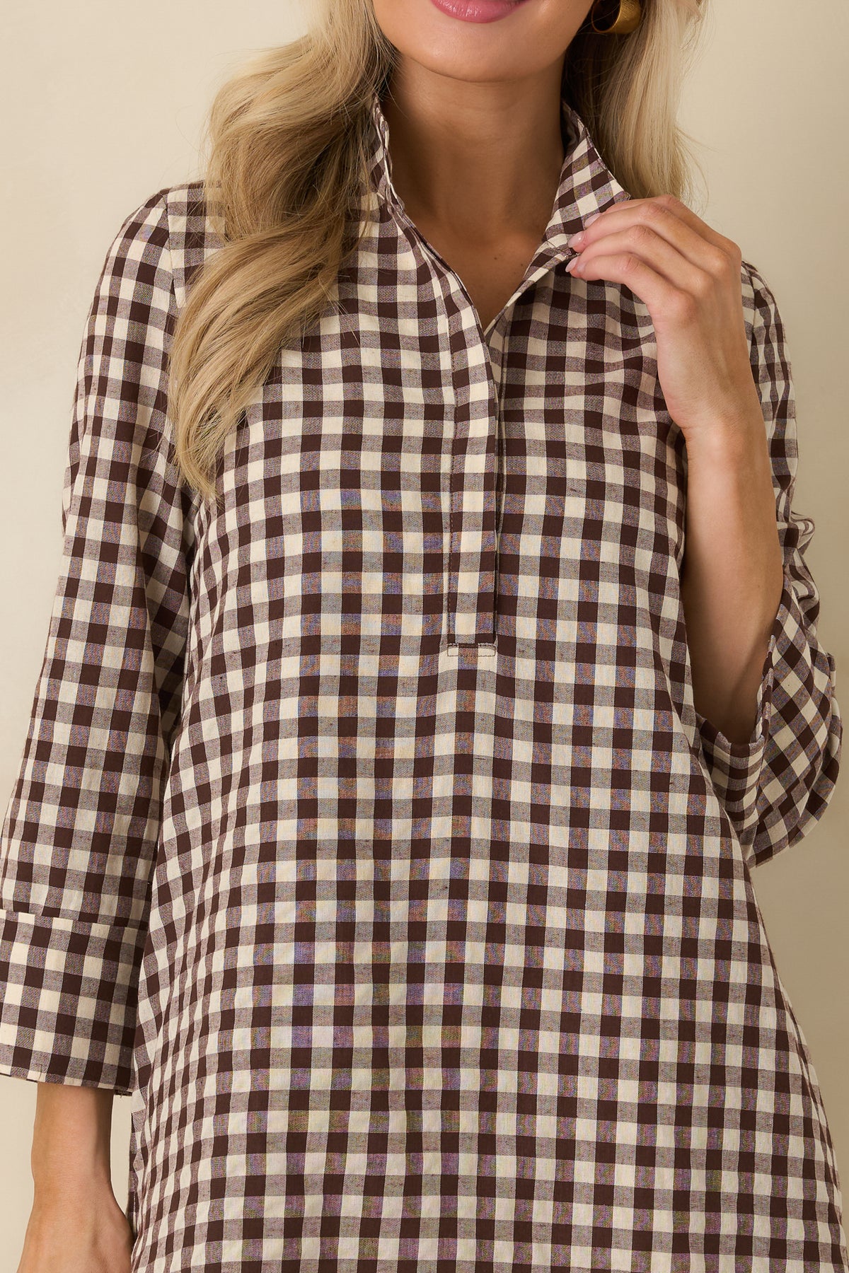 Close-up of the chocolate brown and ivory gingham dress showing its structured stand collar and button placket.