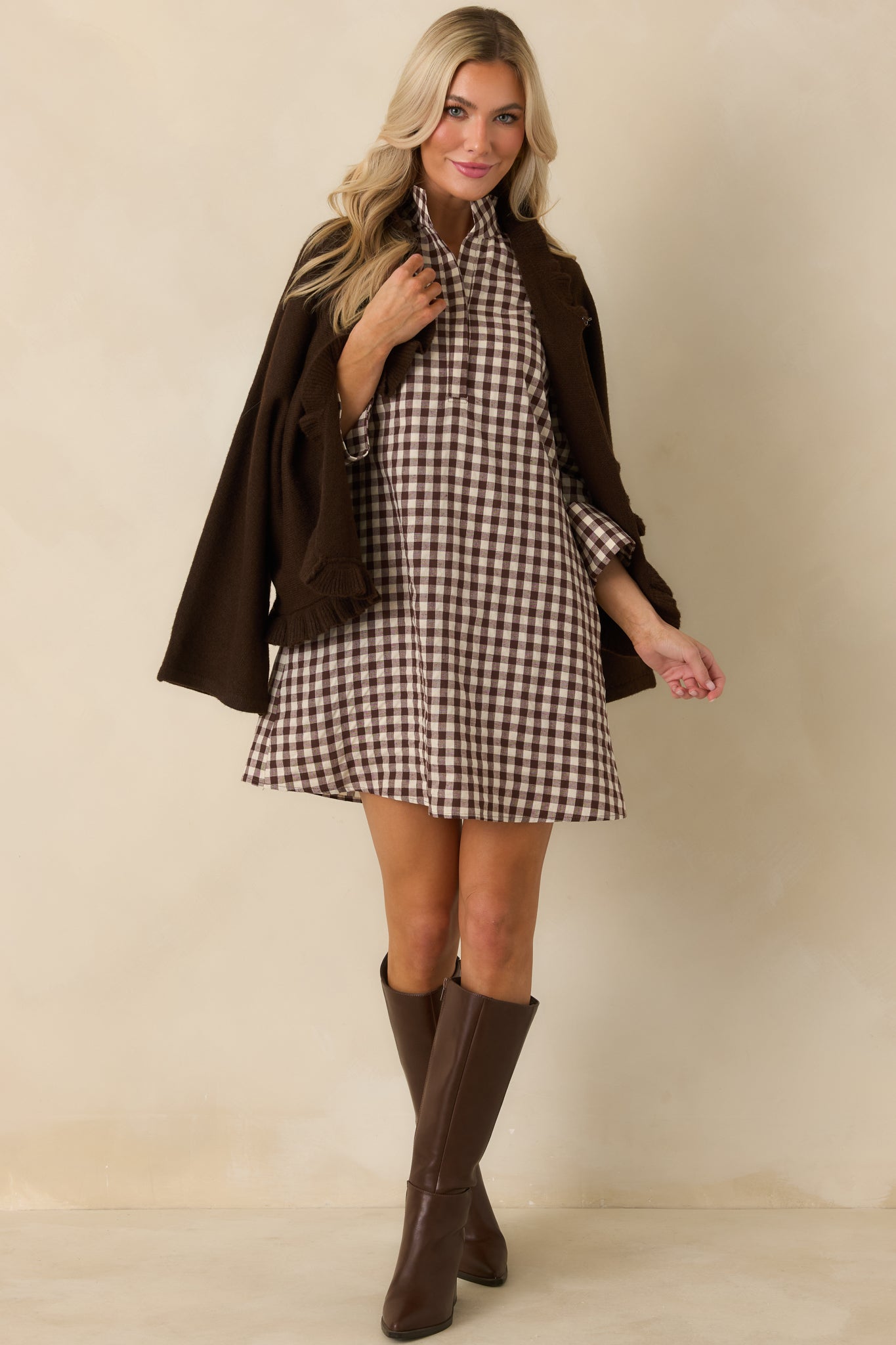 Chocolate brown and ivory gingham mini dress showcasing its structured cotton-blend fabric and polished three-quarter sleeves.
