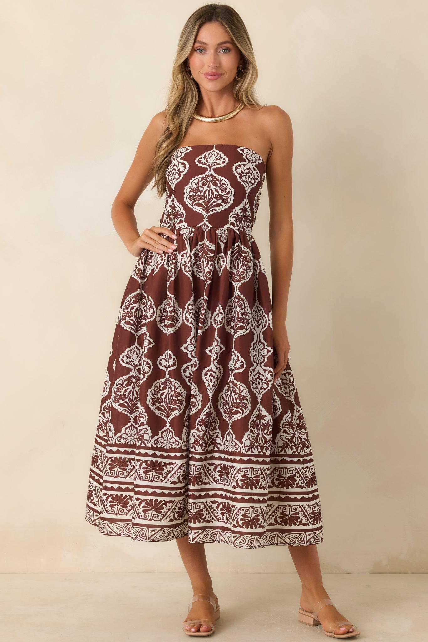 Printed midi dress featuring a chocolate brown and ivory pattern, smocked back, and elegant full skirt silhouette.