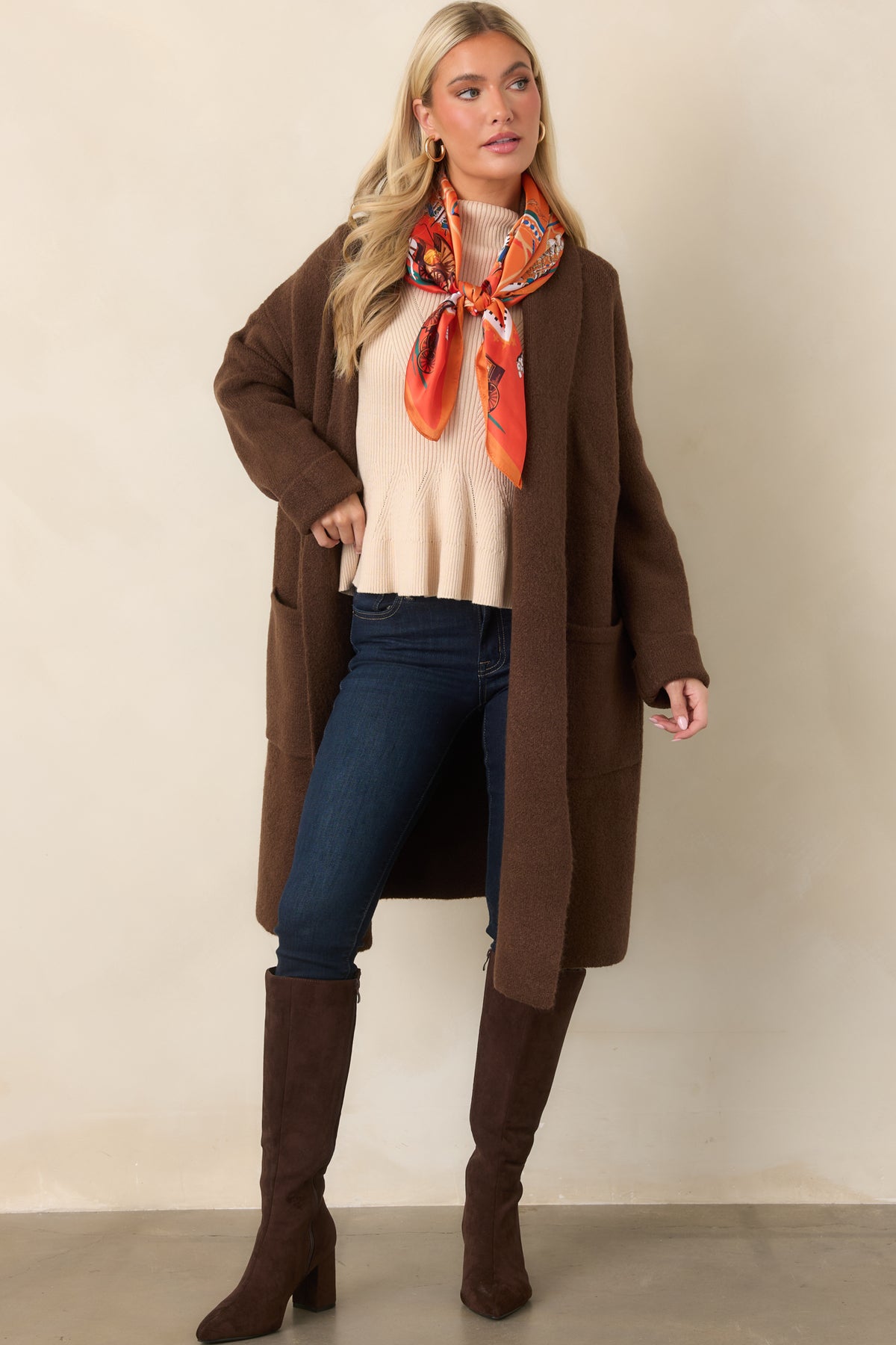 Chocolate brown knit layer with roomy long sleeves, practical patch pockets, and a softly relaxed shape.