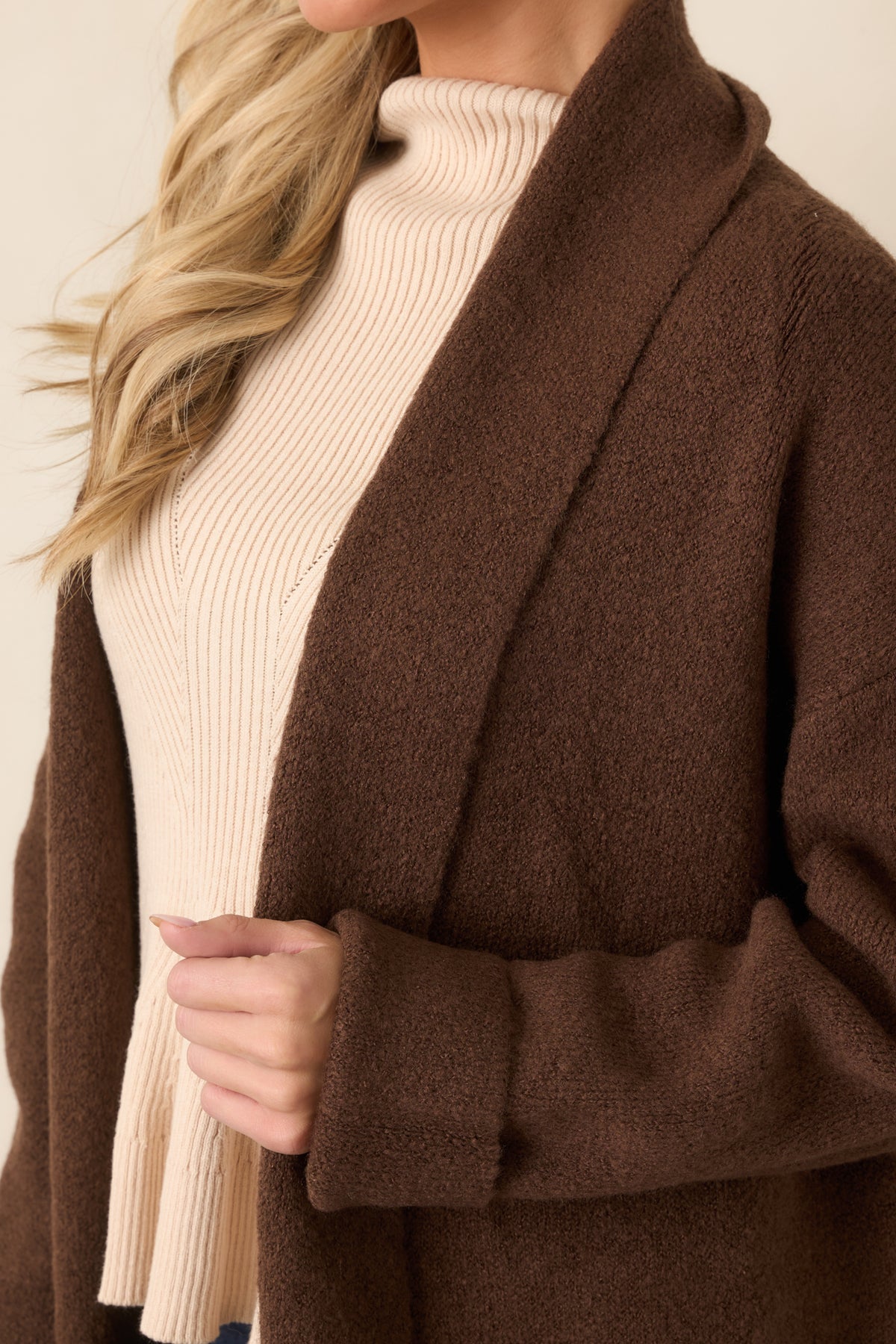 Close view of the rich chocolate knit texture, shawl collar, and open-front construction.