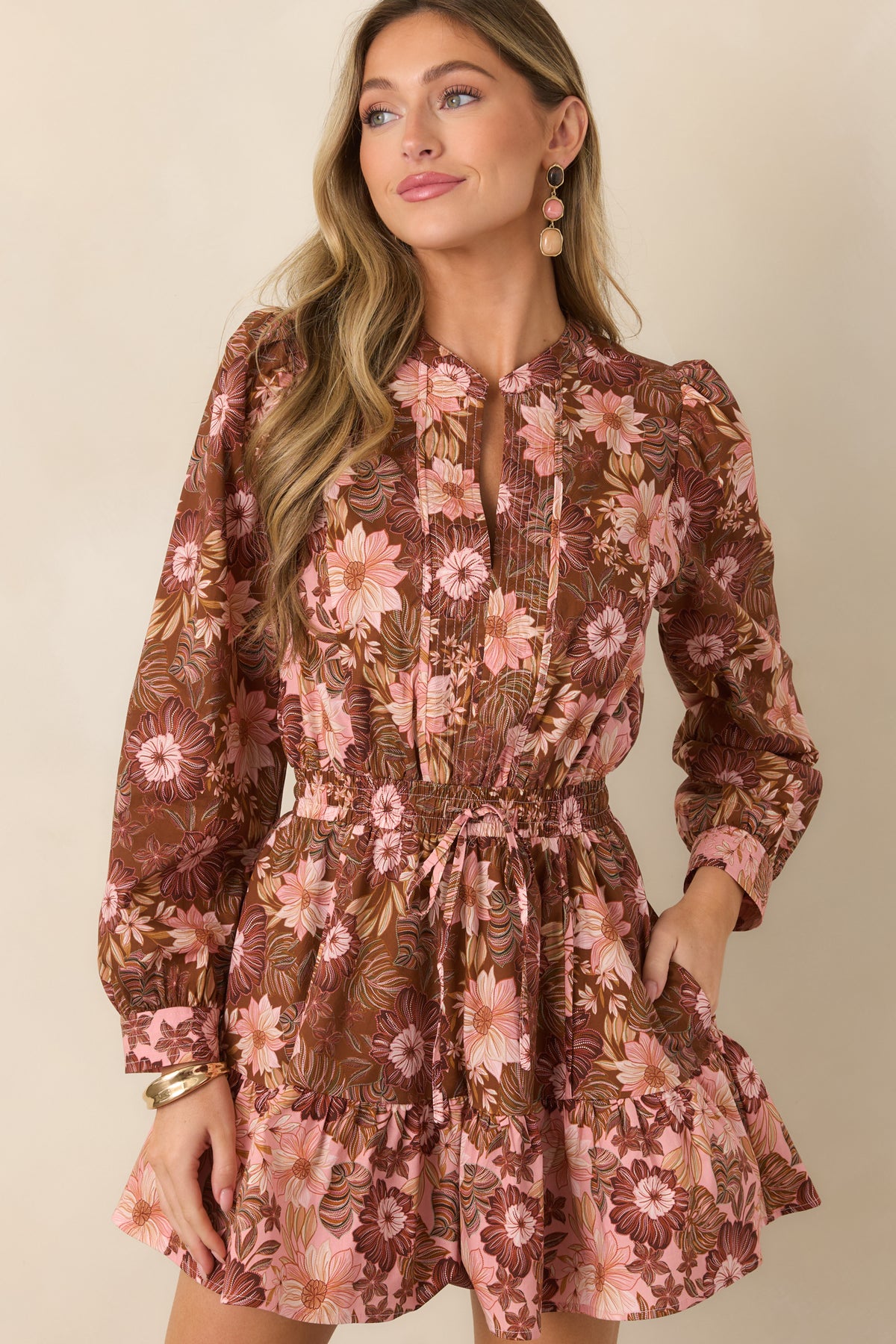 Soft pink, burgundy, and muted green floral print covers this chocolate brown mini dress, accented by a defined gathered waist.