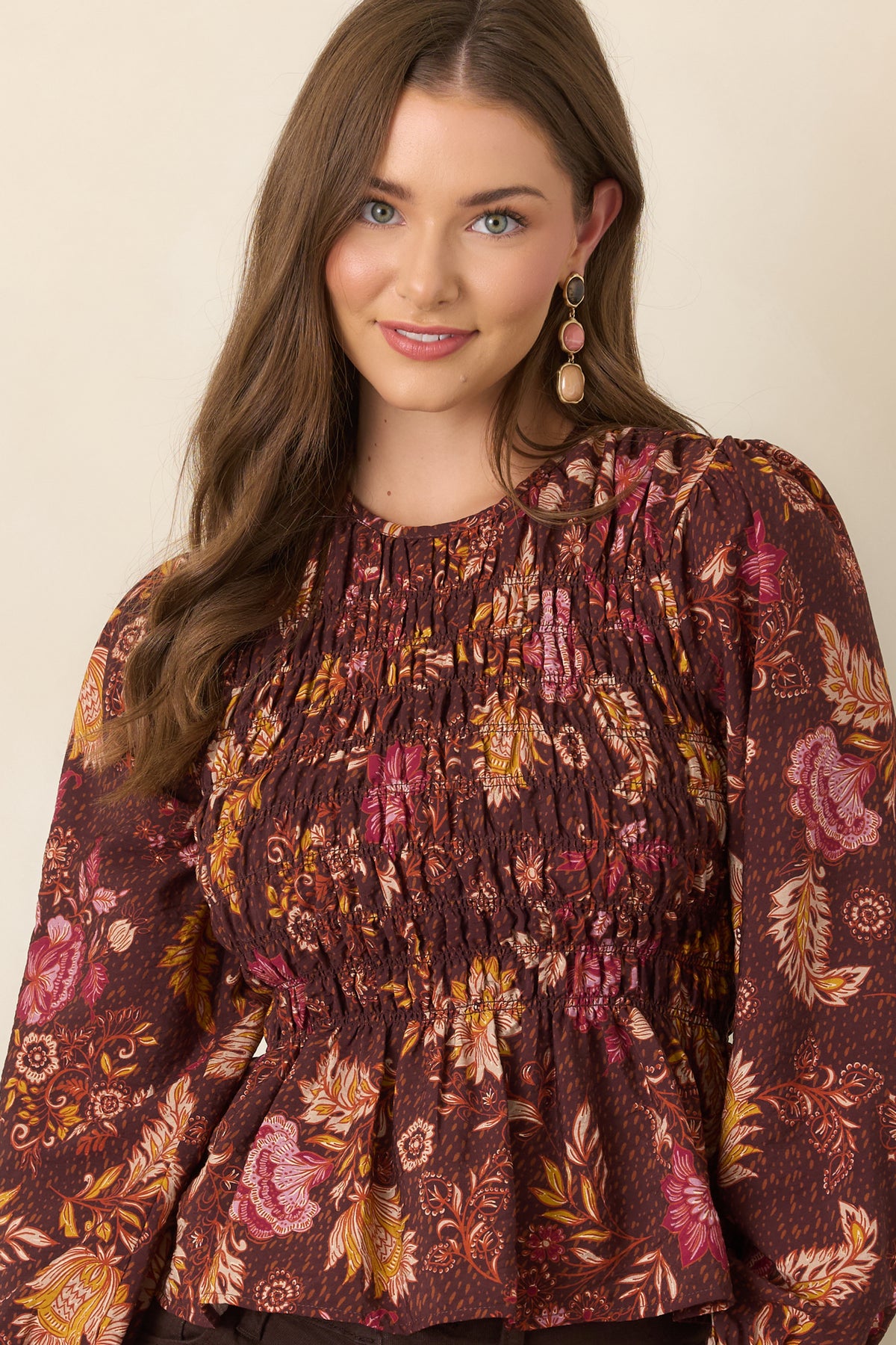 Chocolate brown floral top with pink, ivory, rust, and golden yellow blooms, a smocked bodice, and voluminous puff sleeves.