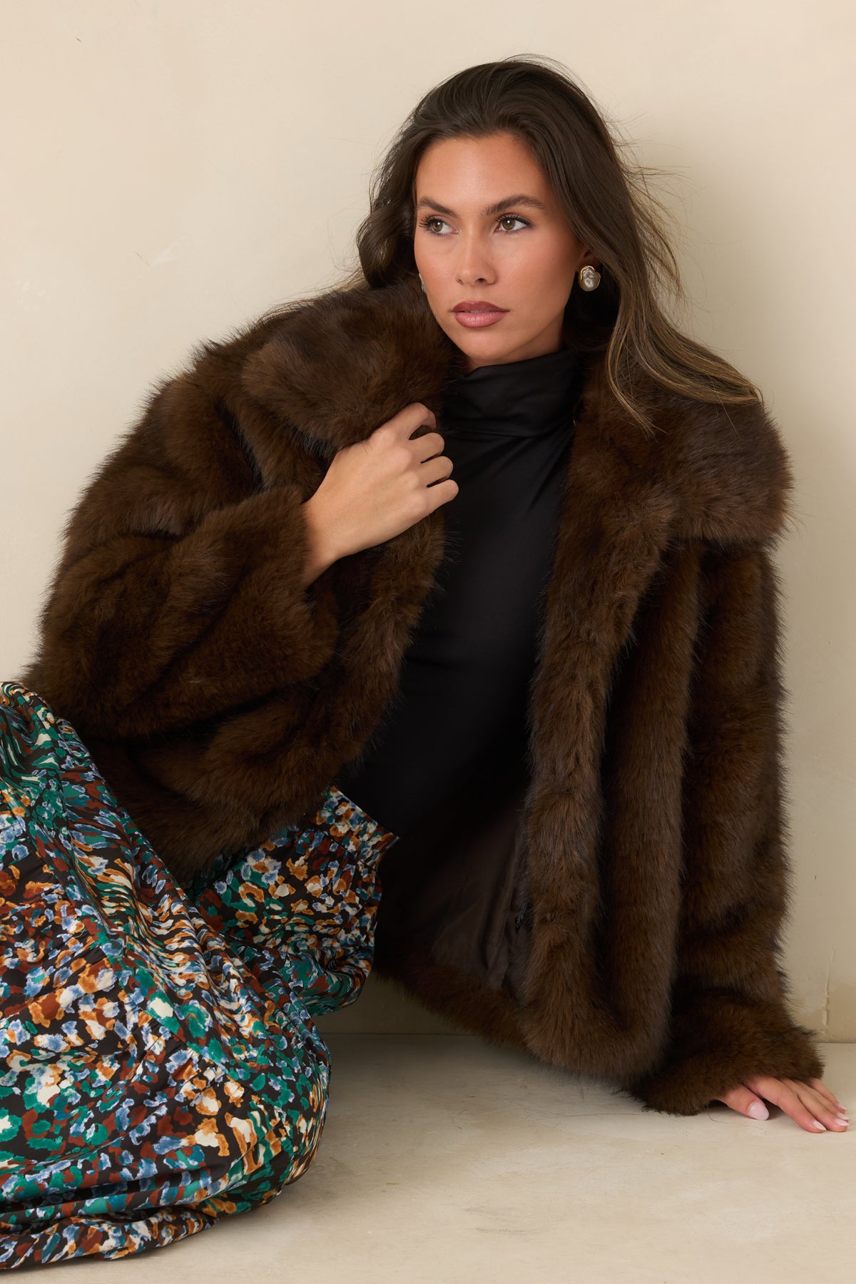  Plush chocolate brown faux fur highlights the generous collar and soft texture of the jacket.