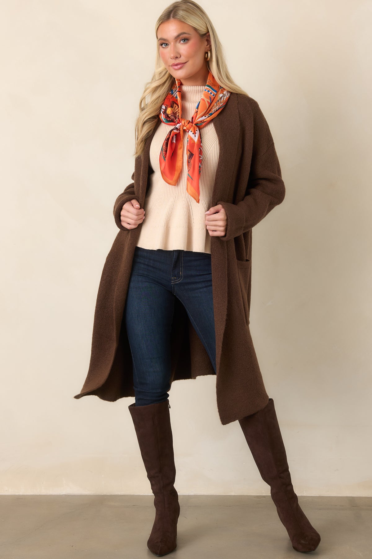 Chocolate brown cardigan with a softly draped shawl collar, open front, long sleeves, and turned-back cuffs.